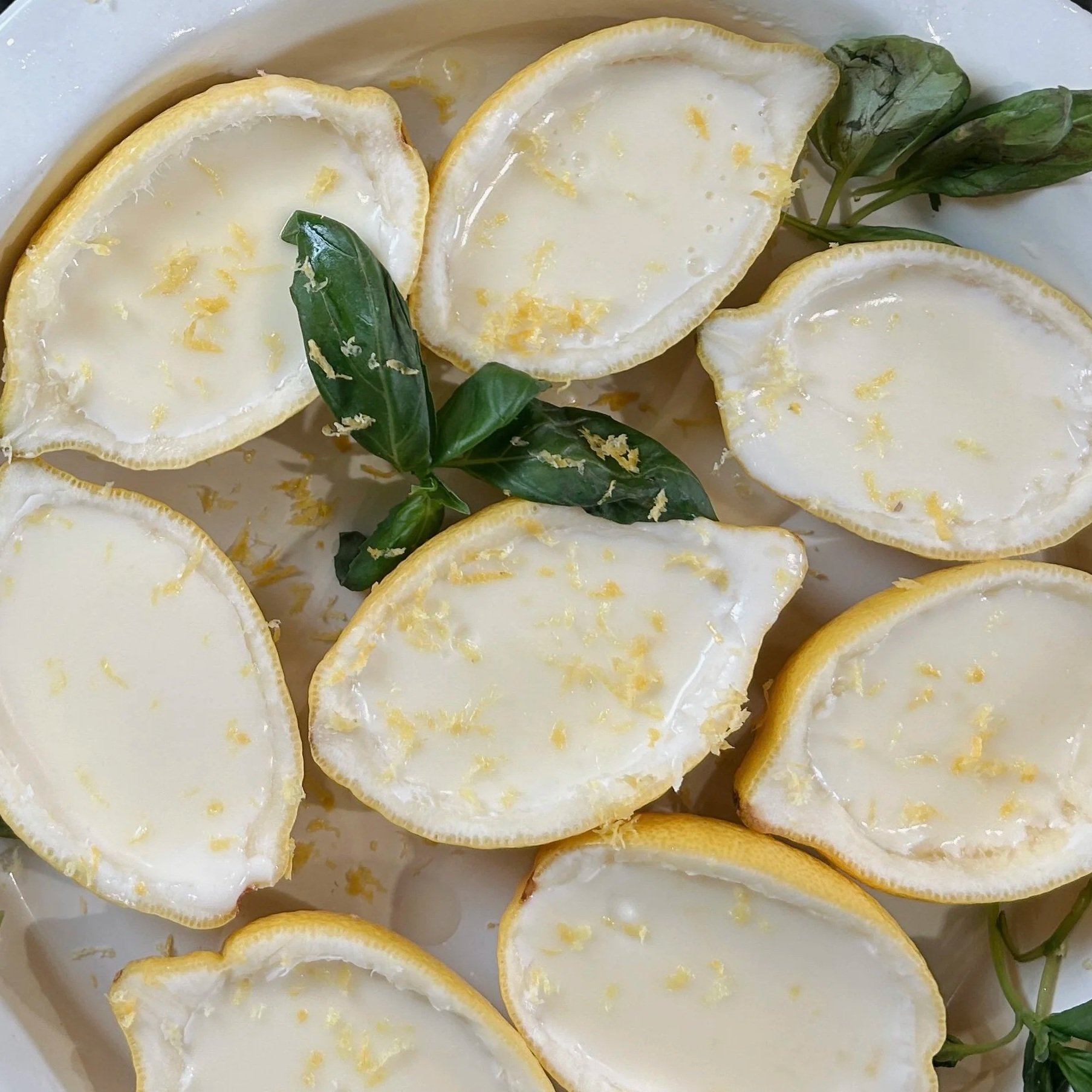 Silky lemon posset served in hollowed lemon shells on a marble surface