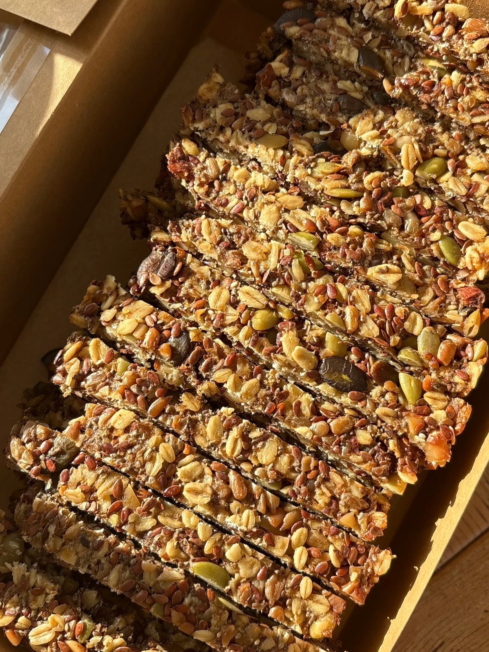 Close-up of a tray of seedy adventure bread cut into rectangular pieces.