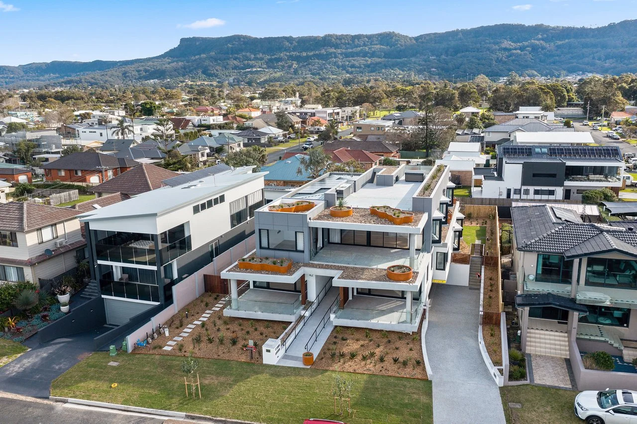 High-level aerial view of Blue Bottle Apartments showcasing custom GRC planters with a rusted steel appearance integrated throughout the multi-level residential facade.