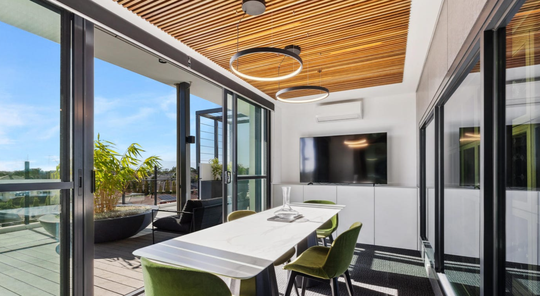 Interior view overlooking landscaped outdoor spaces featuring custom GRC planter bowls, connecting contemporary indoor living with lush communal gardens.