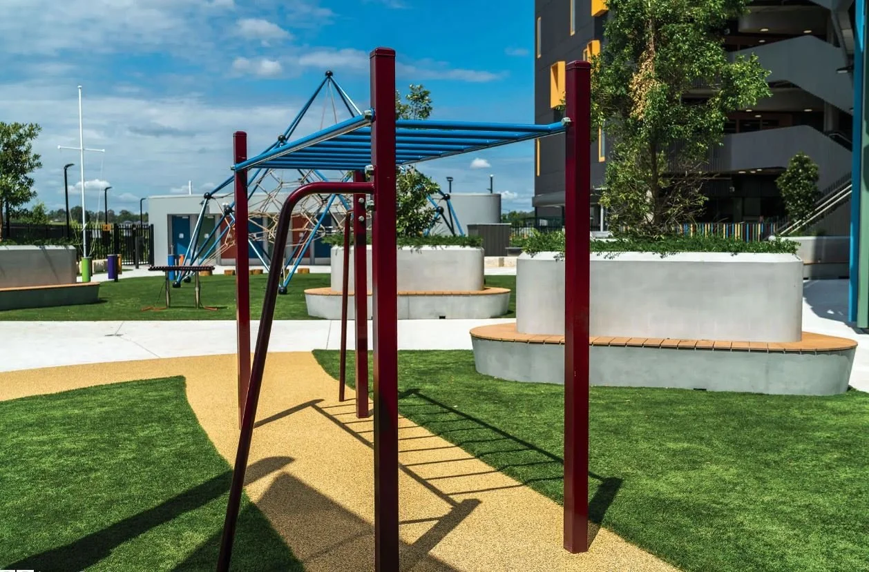 Large circular GRC planter benches installed within a colourful college landscape, providing integrated seating beneath mature trees in a vibrant outdoor setting.