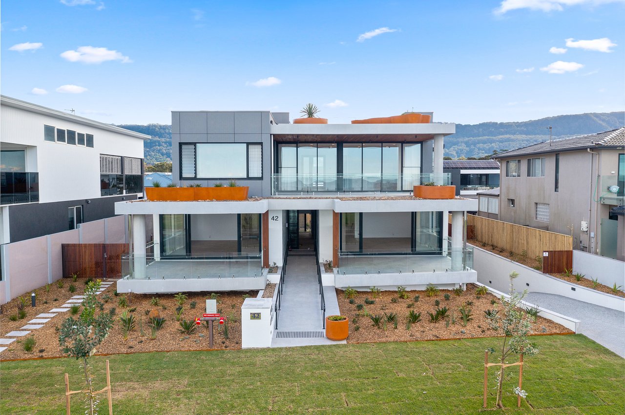 Contemporary apartment building showcasing a variety of custom GRC planter shapes, including rectangular and curved designs, integrated into the exterior architecture.