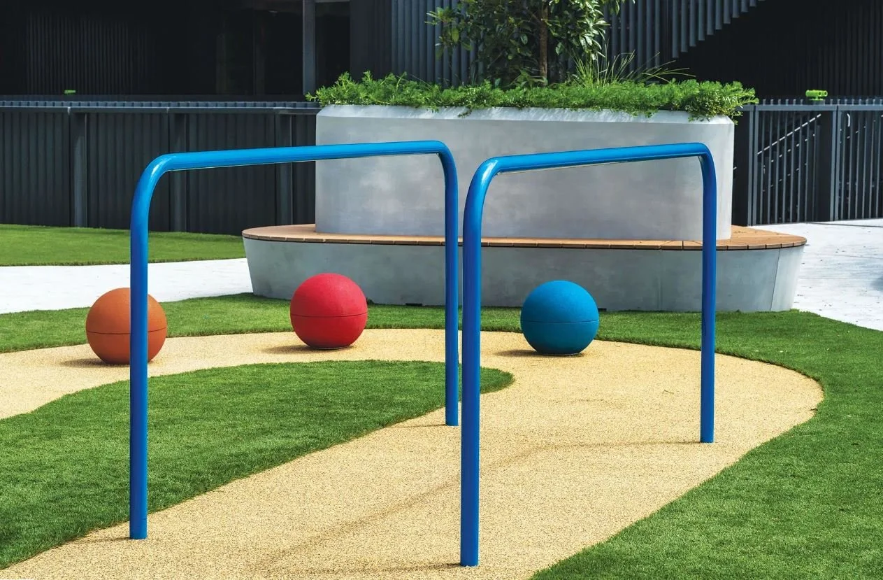 Custom rotunda-style GRC planter benches integrated into a landscaped college plaza, combining generous planting with communal seating in a lively outdoor environment.