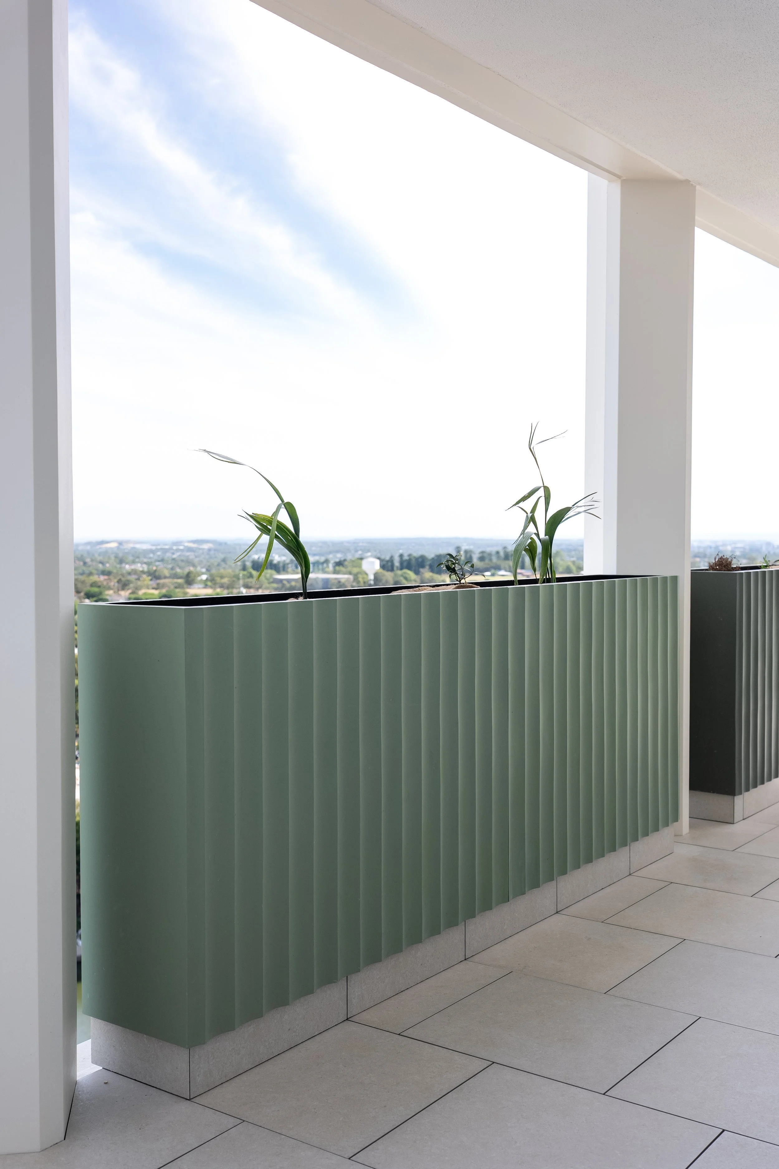 Modern balcony with green ribbed GRC planters manufactured and supplied by Satu Bumi.