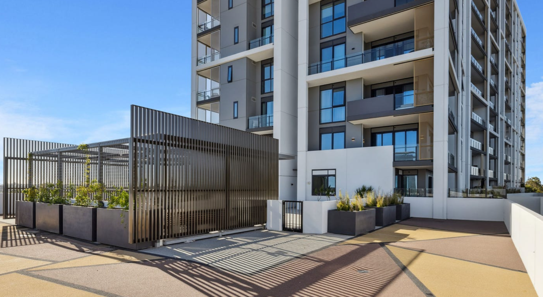 Rooftop terrace featuring large custom rectangular GRC planter boxes defining landscaped outdoor spaces within a contemporary apartment development.