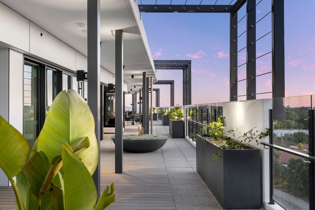 Outdoor community space at a contemporary apartment featuring custom GRC planter bowls and rectangular GRC planter boxes, complemented by comfortable lounge seating and landscaped gardens.