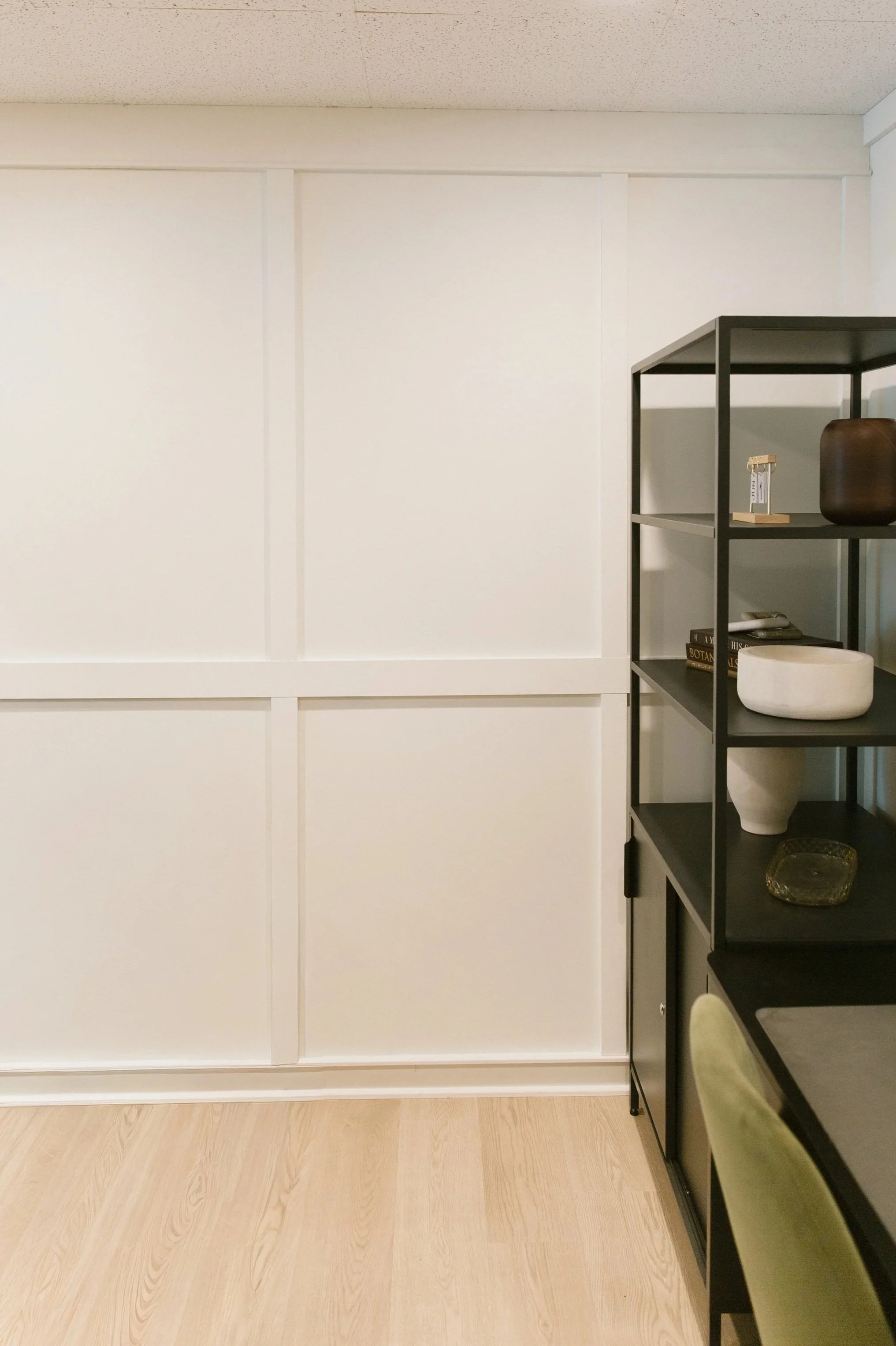 Available private office at The Nook Bend with desk, shelving, and white paneled walls