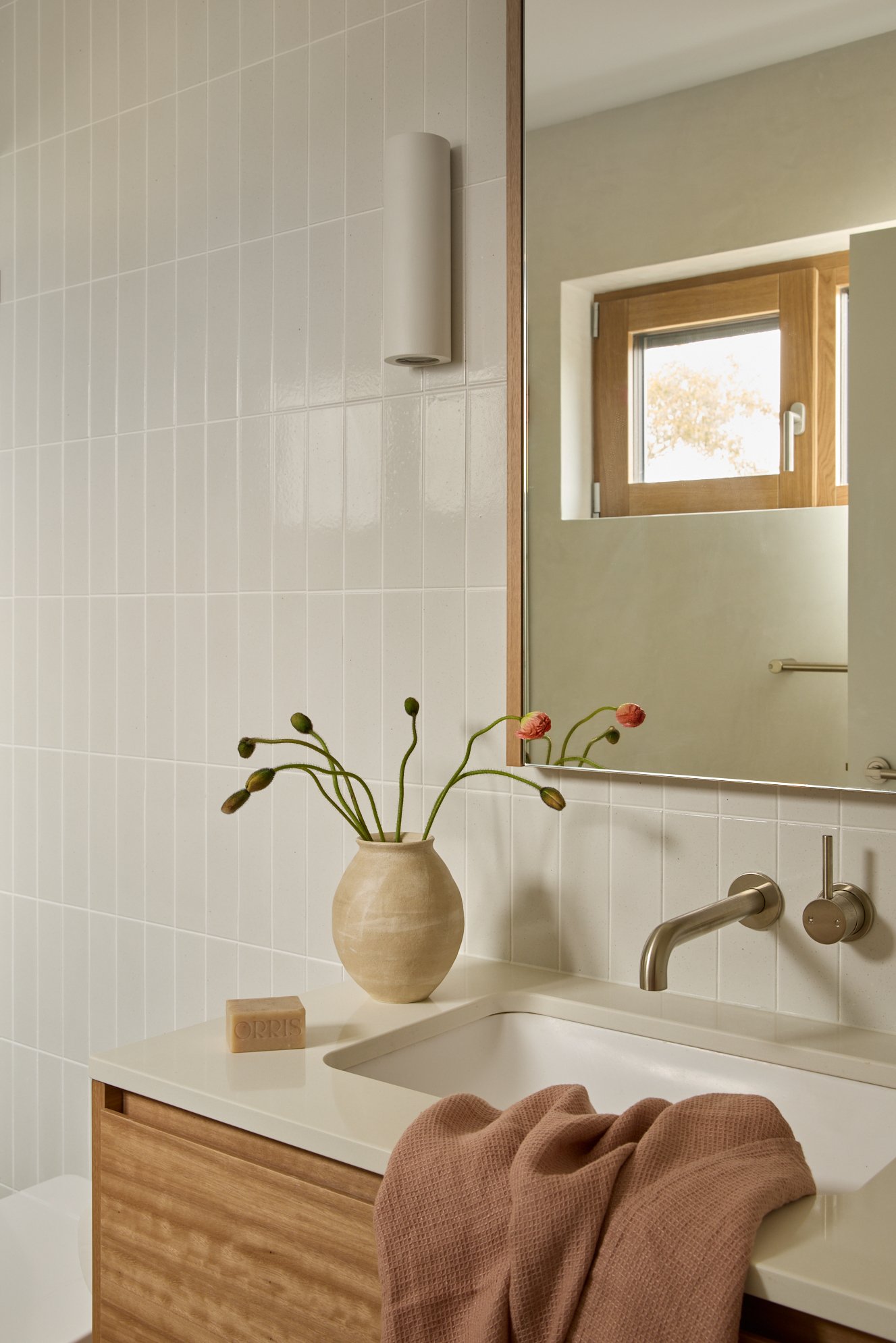 Light-filled terrazzo tiled bathroom in Jindabyne with timber vanity and wall-mounted tapware
