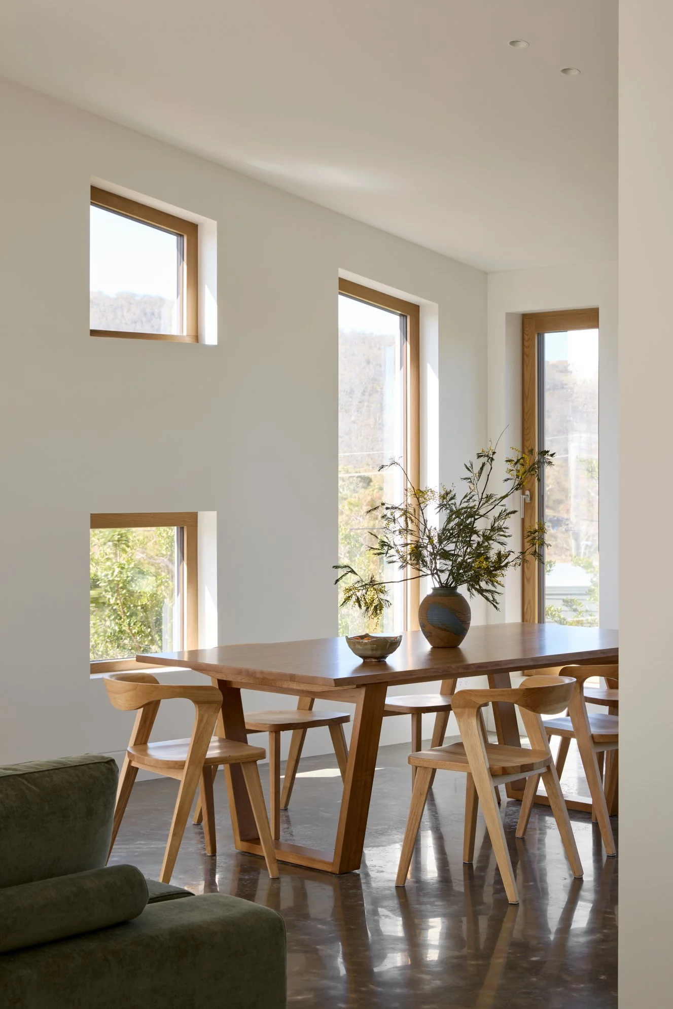 Light-filled dining room interior design in Jindabyne with burnished concrete floors and custom oak windows