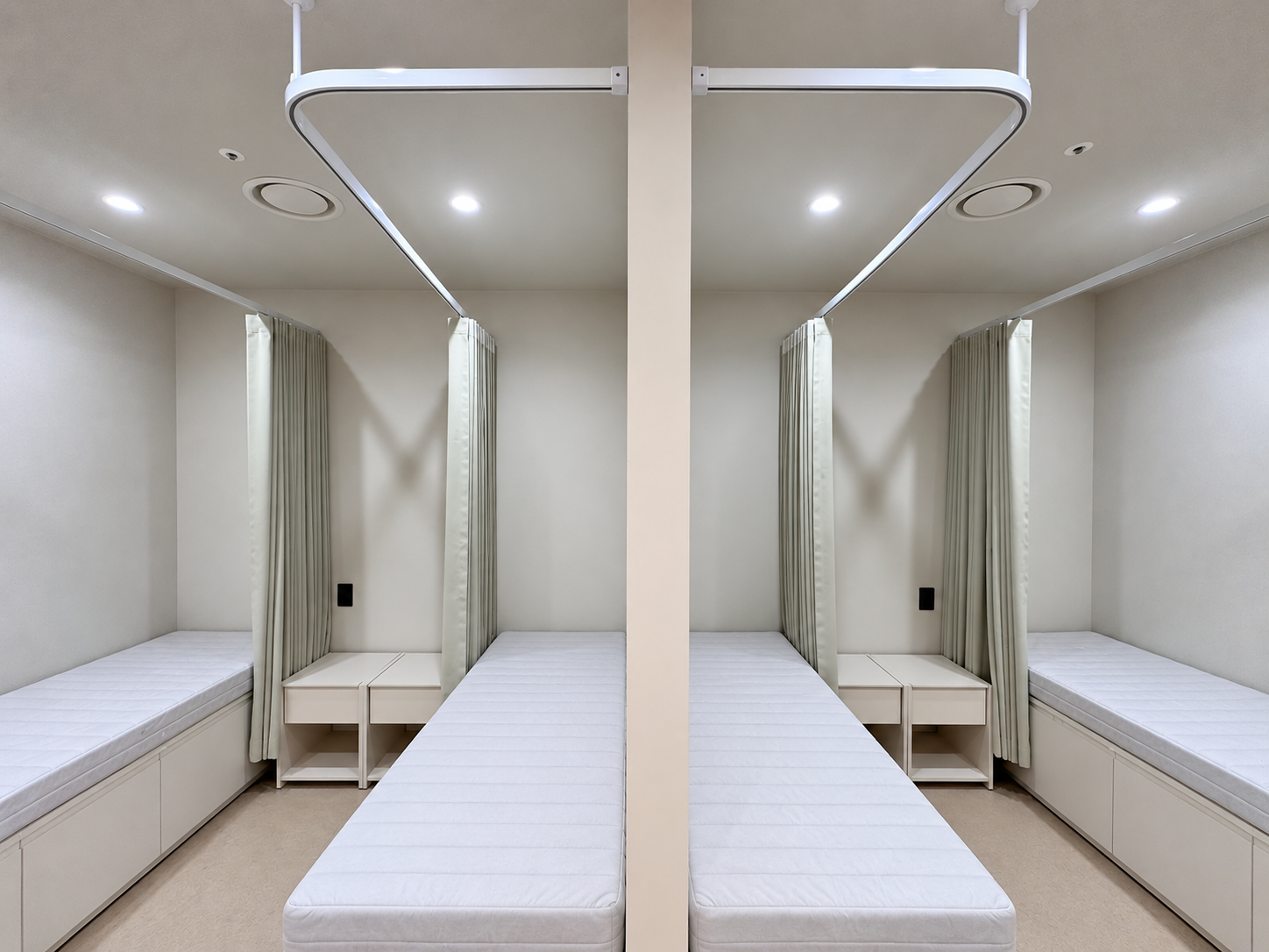 정렬된 레일과 깨끗한 네 침대 치료실.png