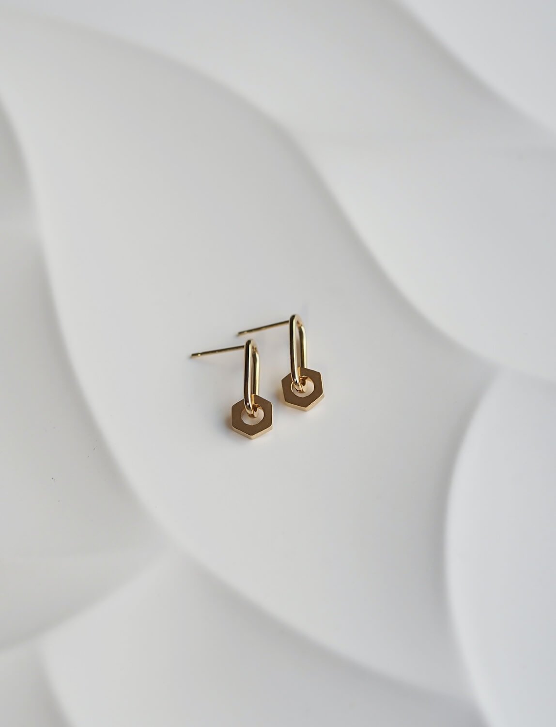 Gold minimalist rectangle drop earrings with a hex pendant detail