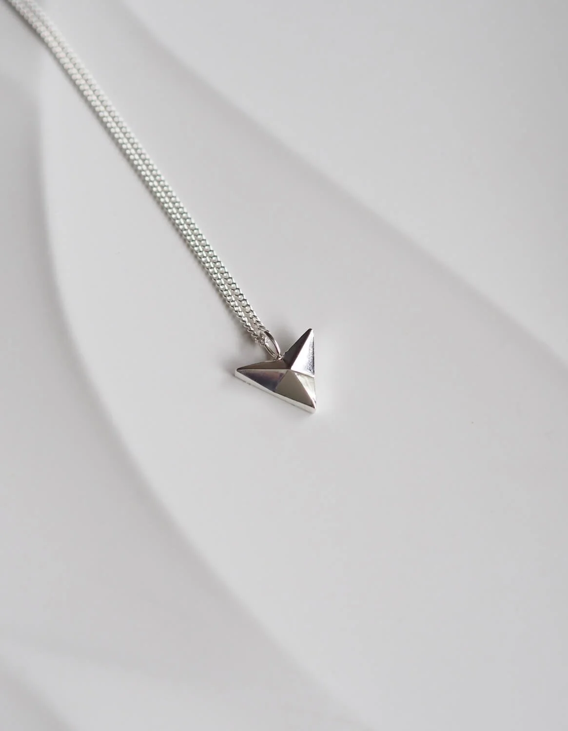 Silver arrowhead pendant necklace on curb chain