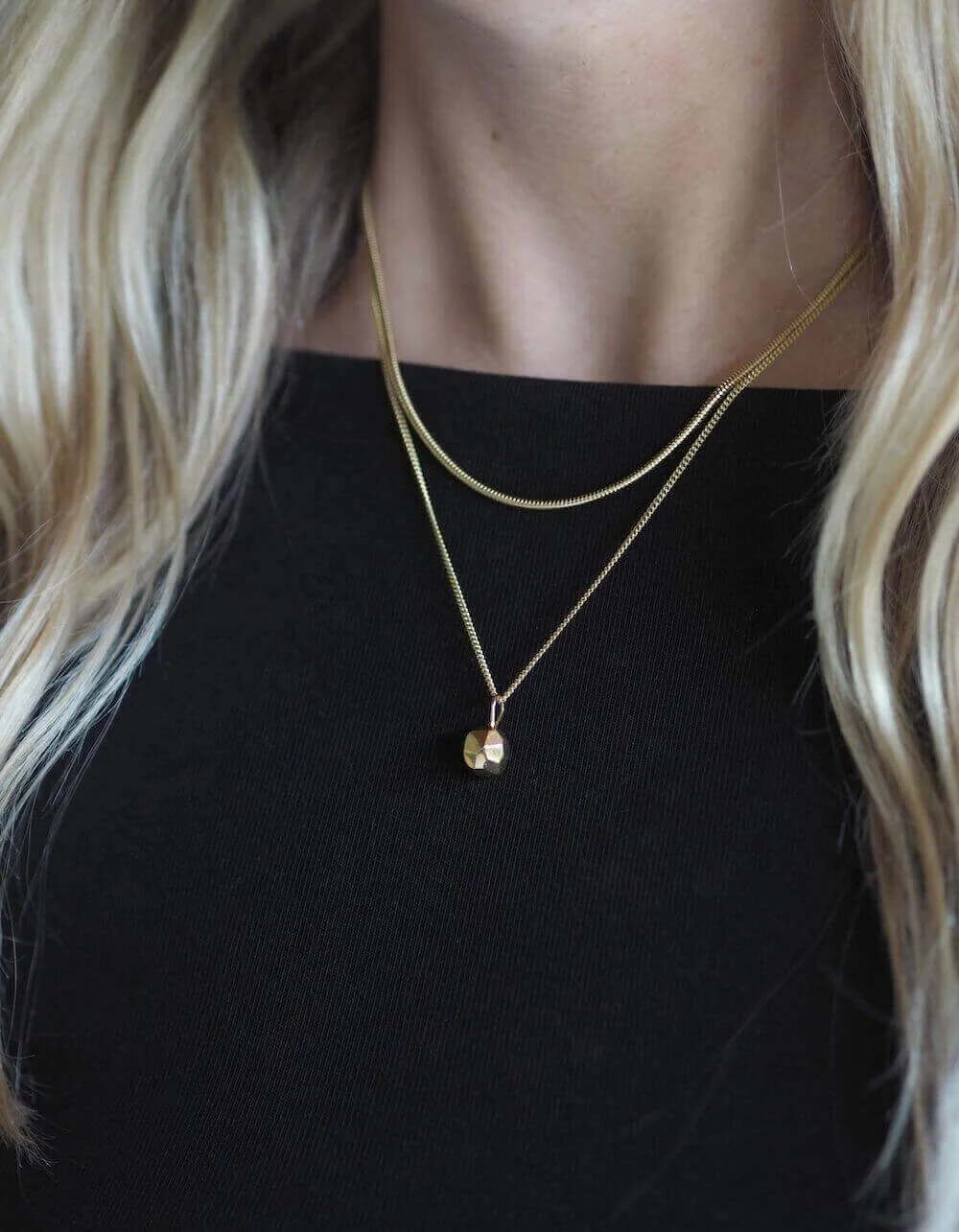 Gold faceted ball pendant necklace on a curb chain