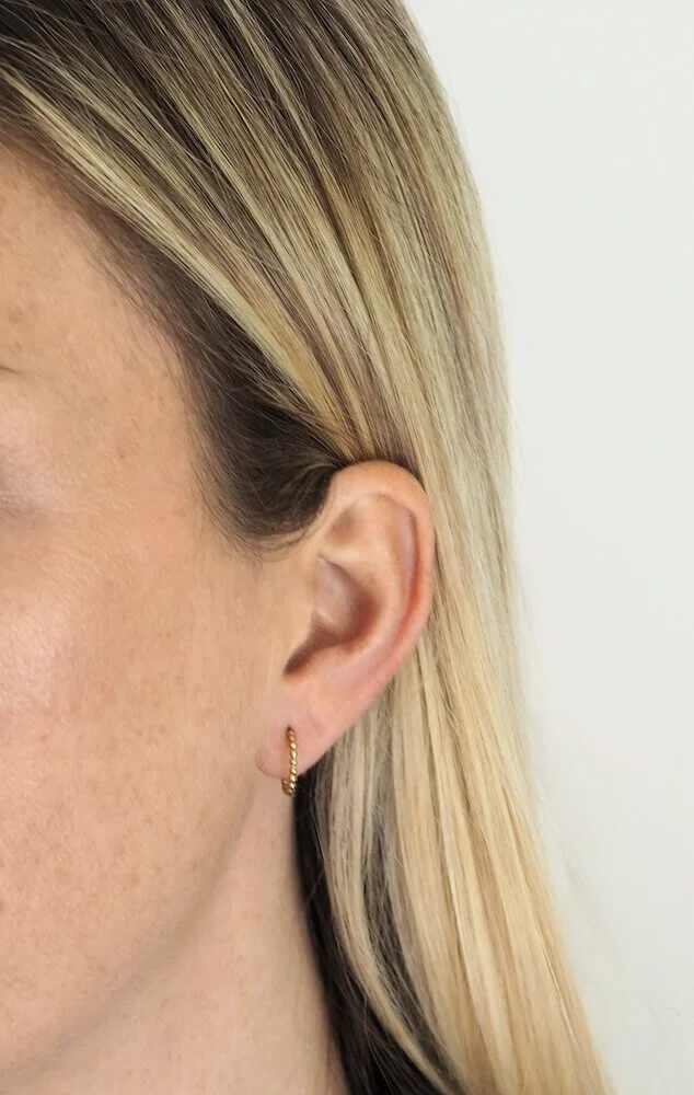 Gold beaded hoop earrings modelled