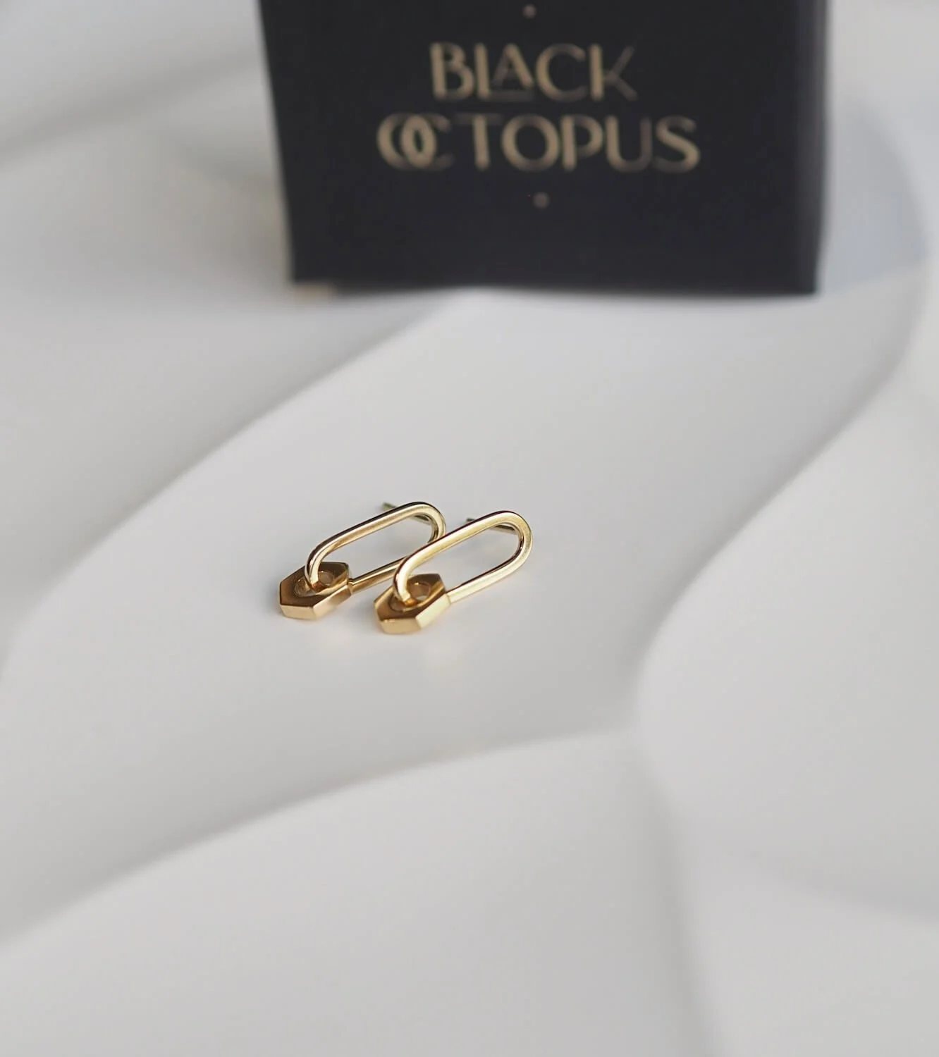 Gold modern drop earrings with a hex nut drop detail