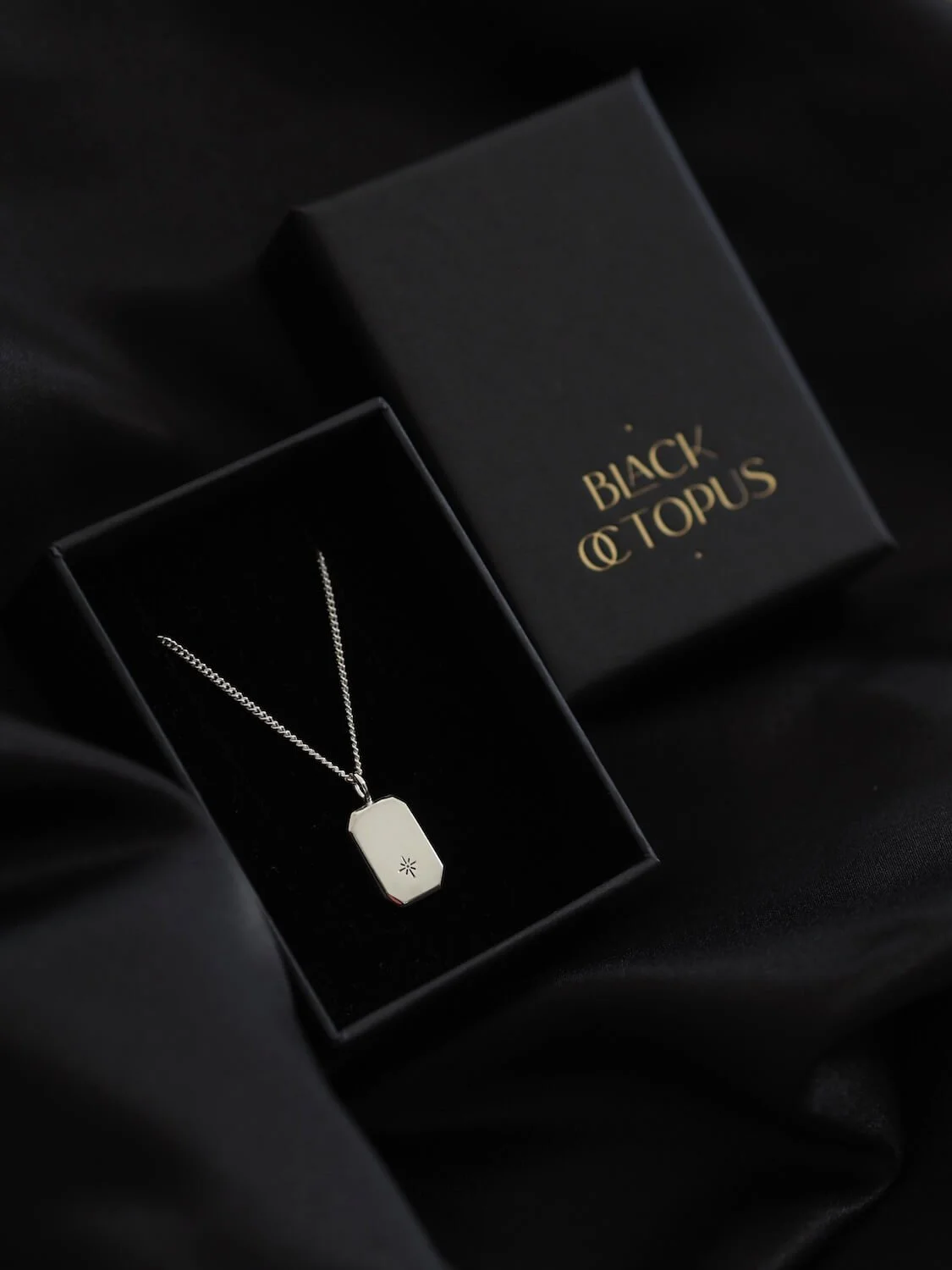 Silver rectangular star pendant on modern curb chain