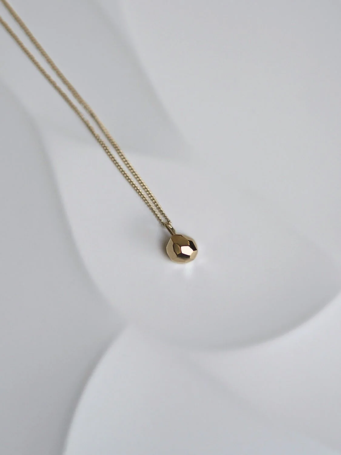 Gold faceted ball geometric pendant on curb chain