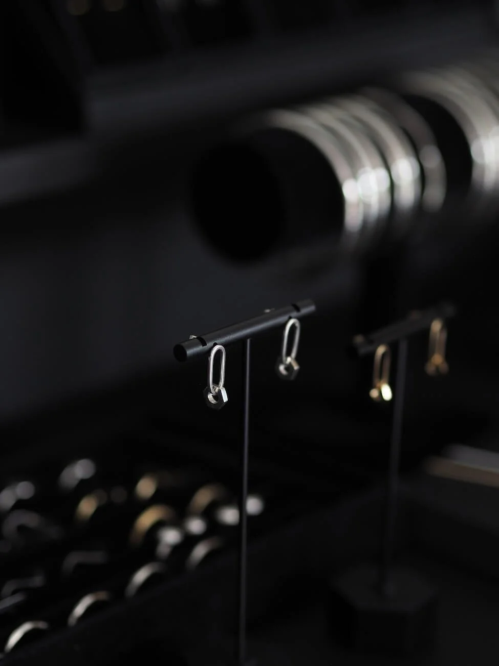 Silver hex drop earrings displayed with other jewellery
