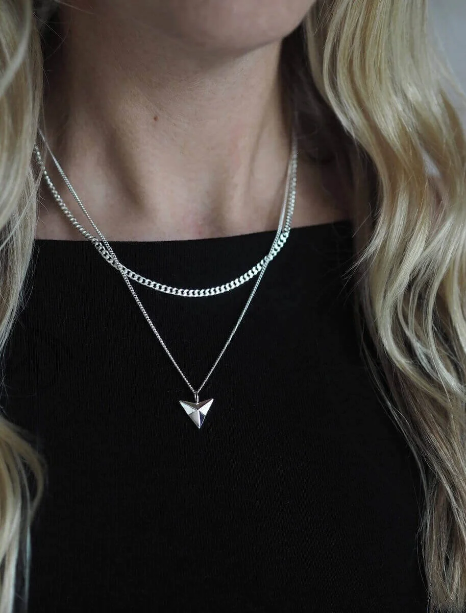 Silver arrowhead pendant on a curb chain modelled