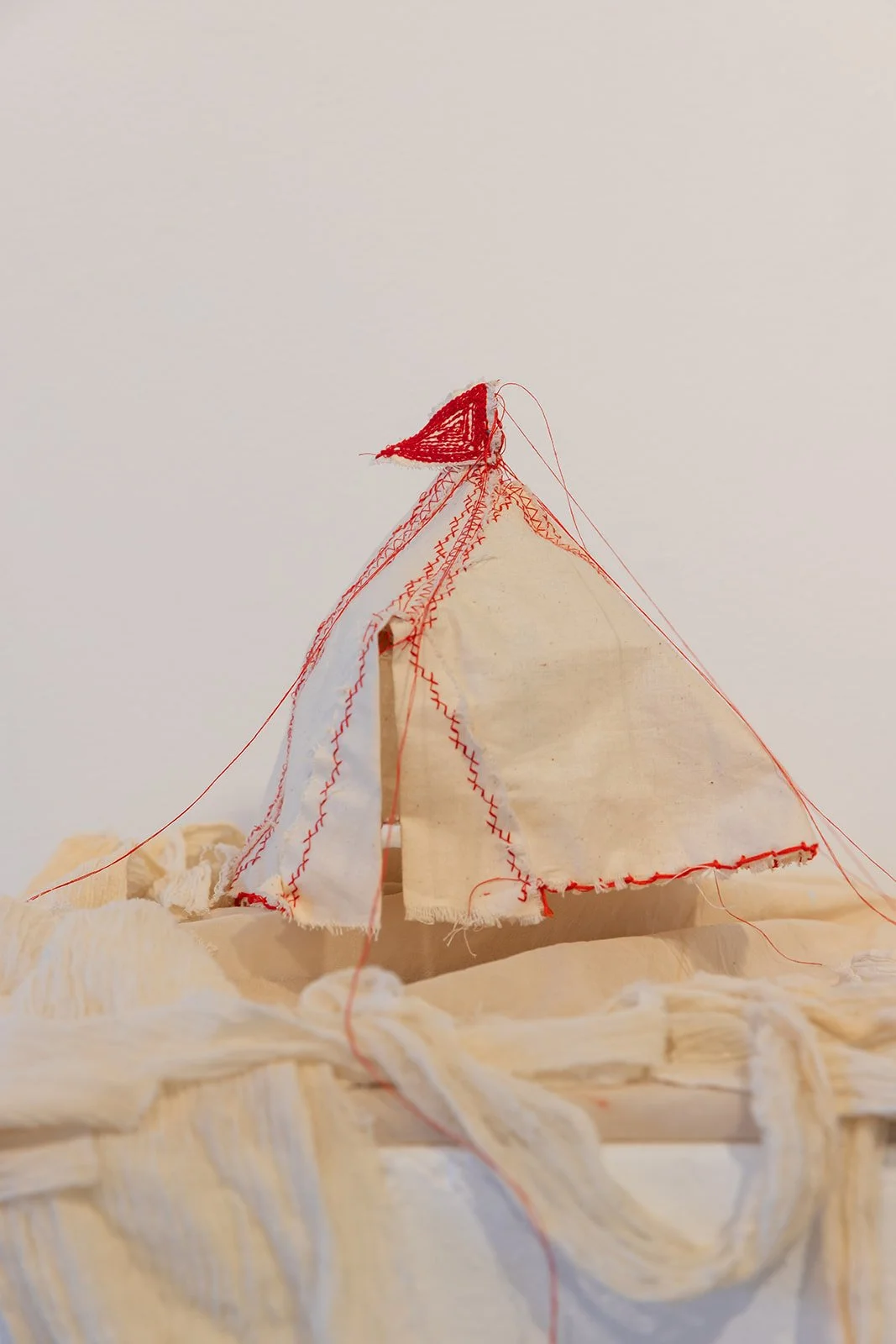 Chelsea Carkeet, Show Business I, 2024, calico, red cotton thread, electrical wire, cotton paper, armature wire, mdf board, dowel, gauze, 20cm x 20cm x 25cm. Photo by Robyn Wood. 