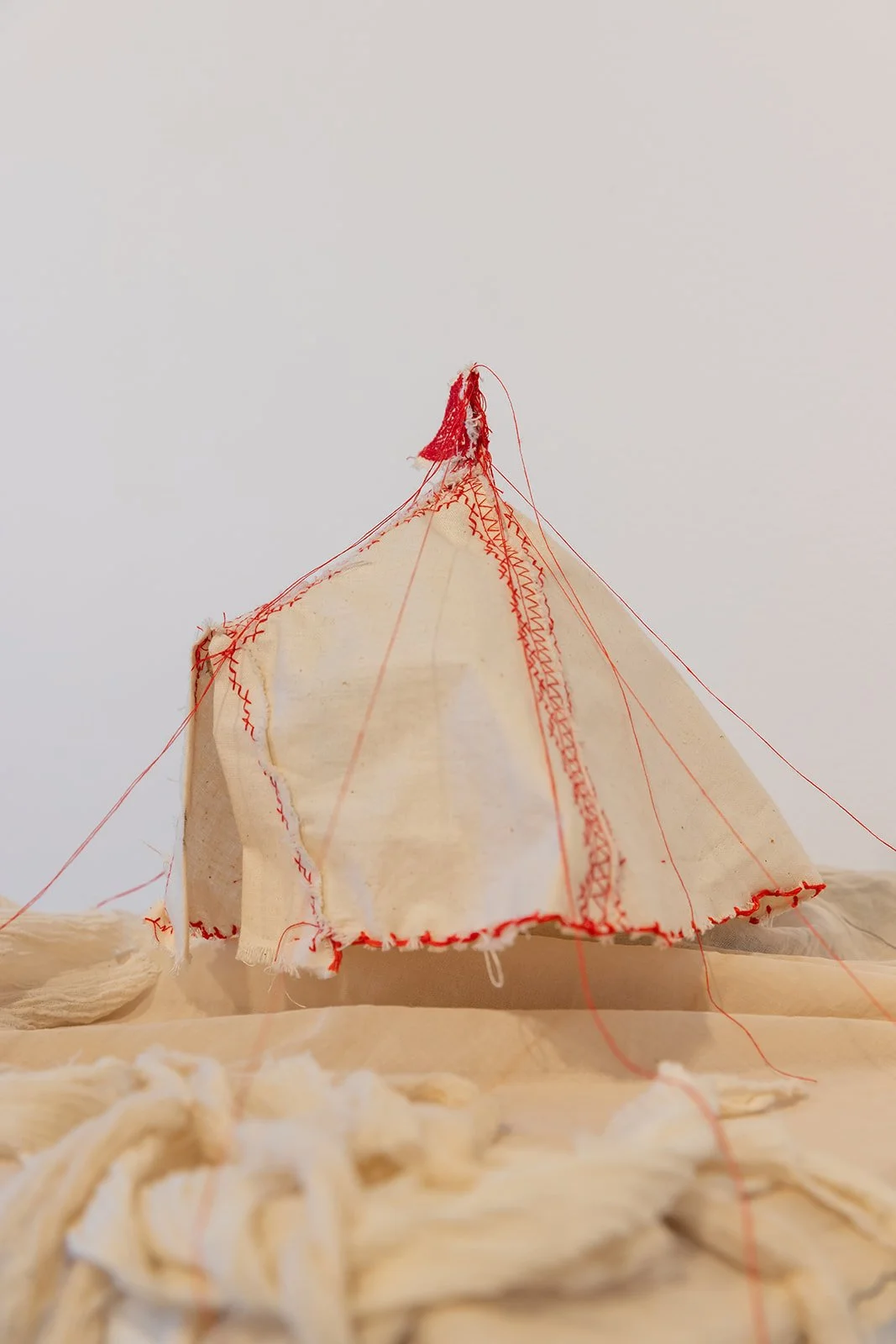 Chelsea Carkeet, Show Business I, 2024, calico, red cotton thread, electrical wire, cotton paper, armature wire, mdf board, dowel, gauze, 20cm x 20cm x 25cm. Photo by Robyn Wood. 