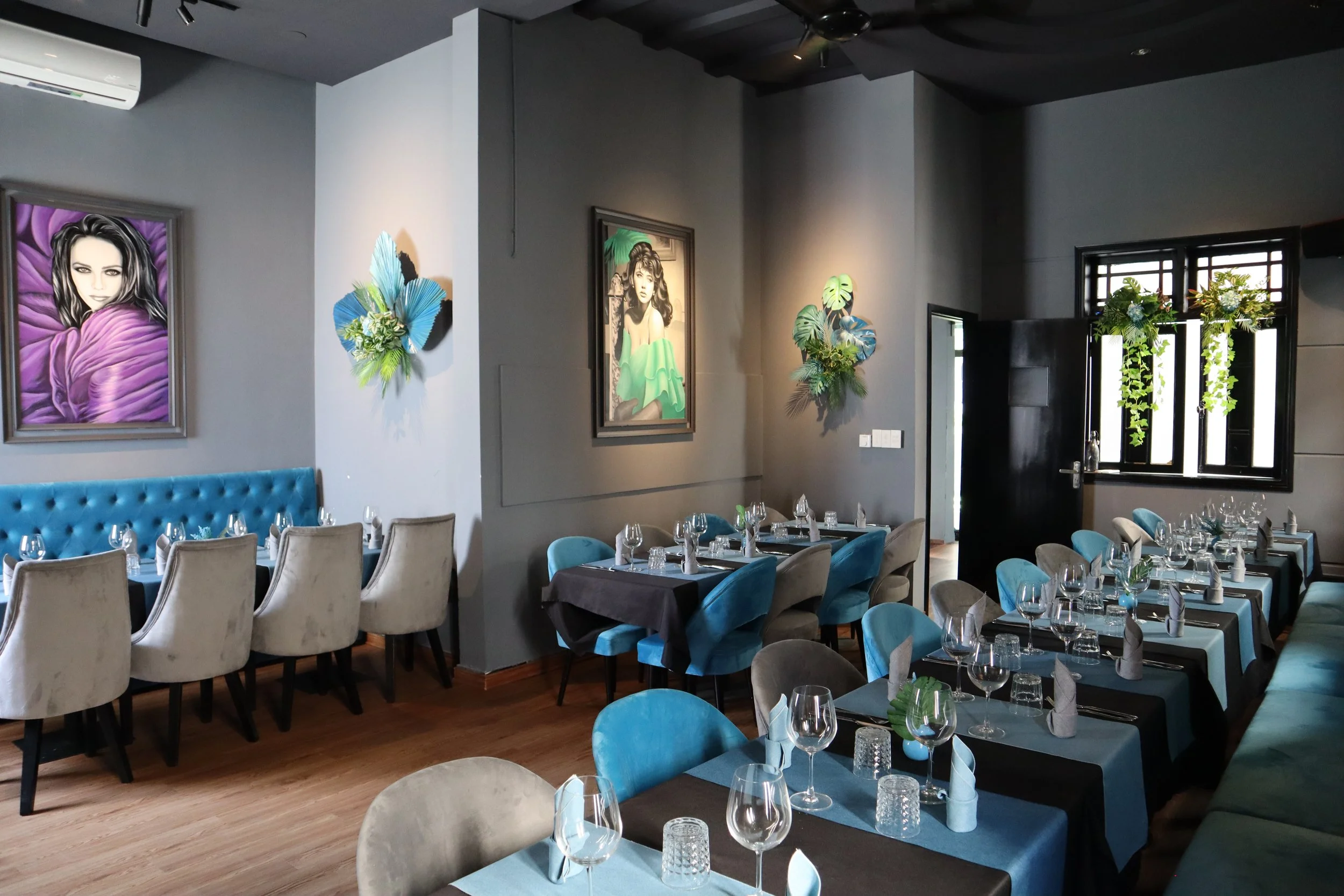 Comfortable indoor seating with AC, and French actress paintings in Le Rendez-Vous, gourmet French restaurant in Da Nang, Vietnam
