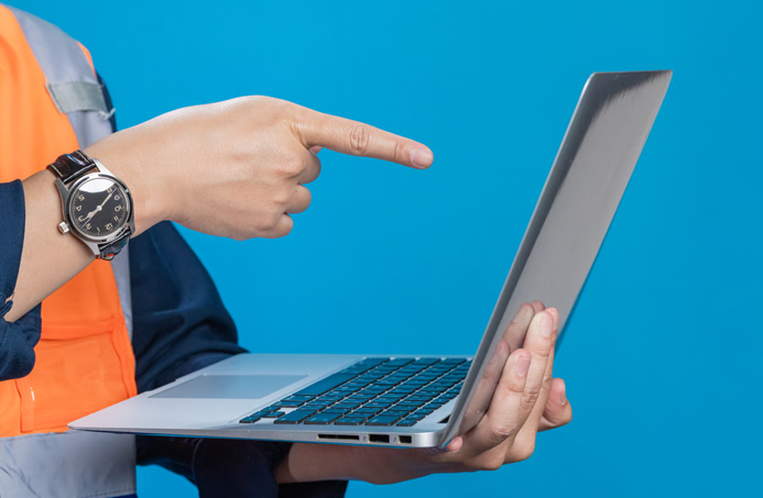 A worker pointing to a laptop screen for simple intranet maintenance.