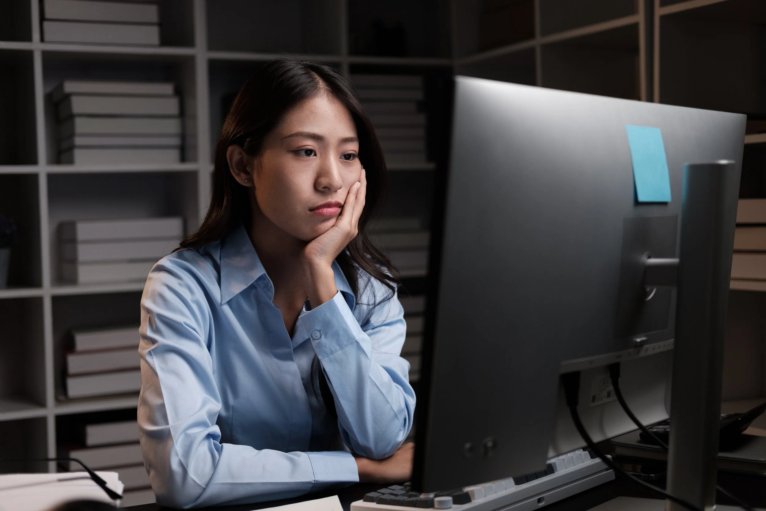 Woman working late at computer and checking something