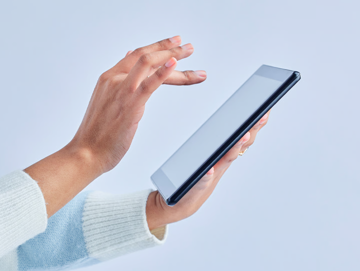 Person in striped sweater using tablet.