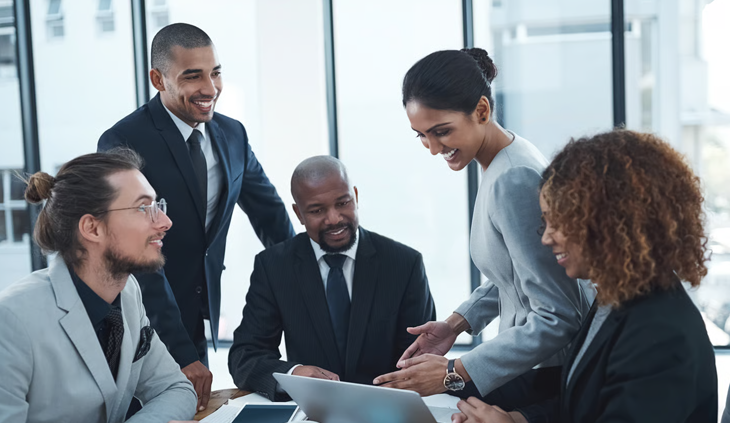 A professional business team collaborating around a laptop in the office.