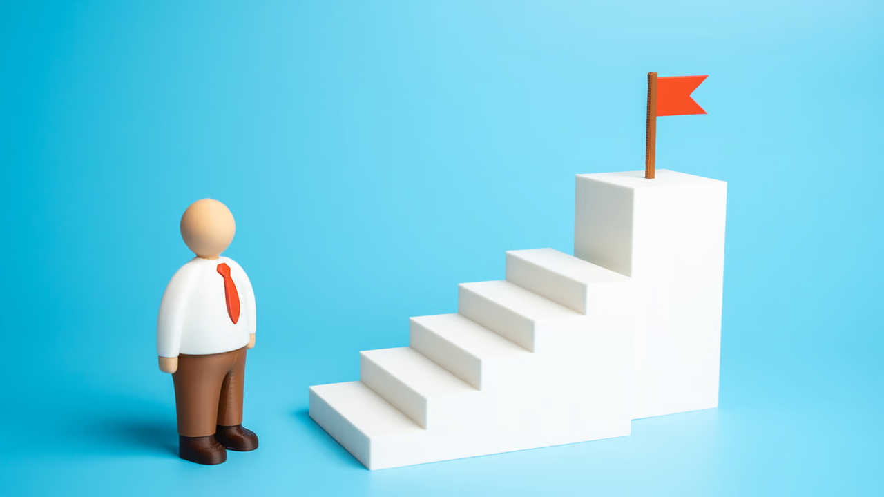 Corporate figure standing at the base of a white staircase with a red flag