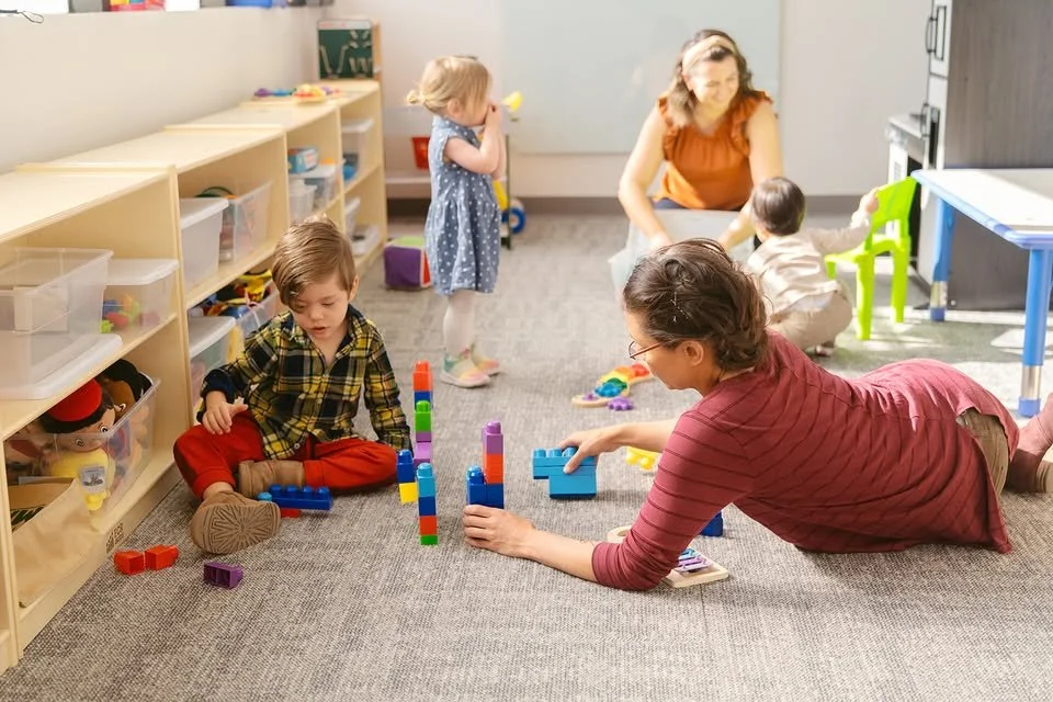Mothers engaging in play activities with their children at Soar Autism Center