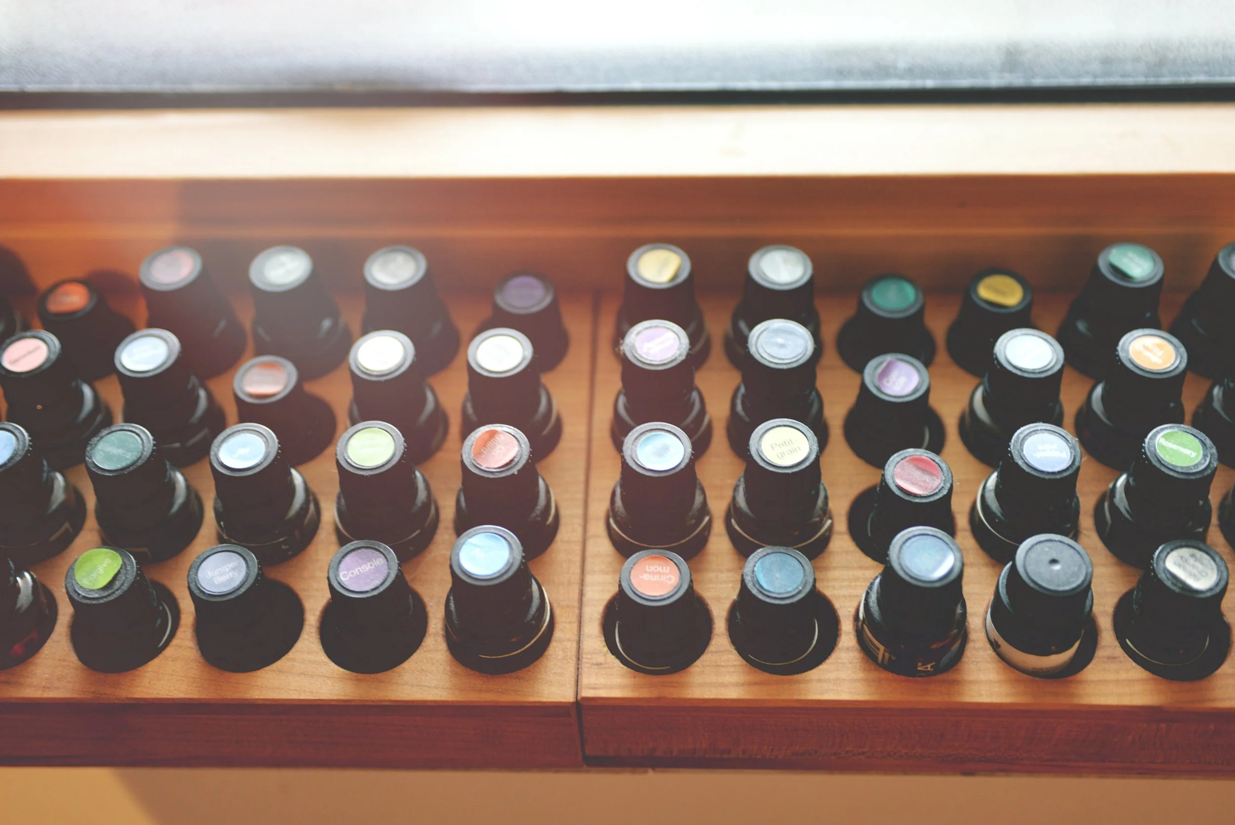 Collection of essential oil bottles on a wooden surface.