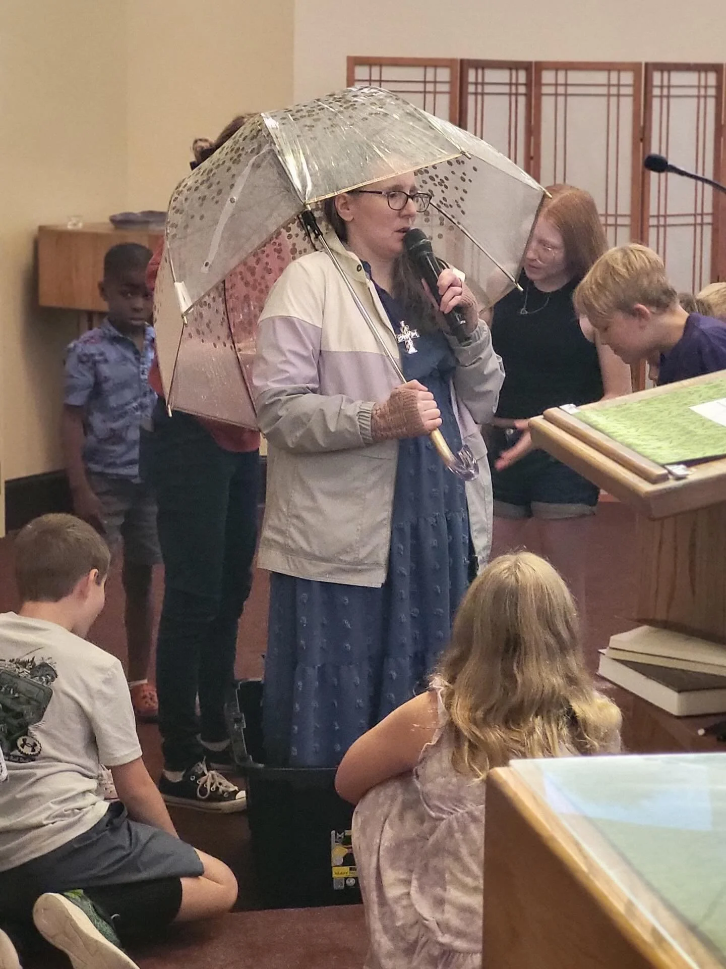 God is our shelter! Pastor Katie wore her rain gear and the kiddos poured water on her as she was (mostly) protected from getting wet. How is God your shelter?