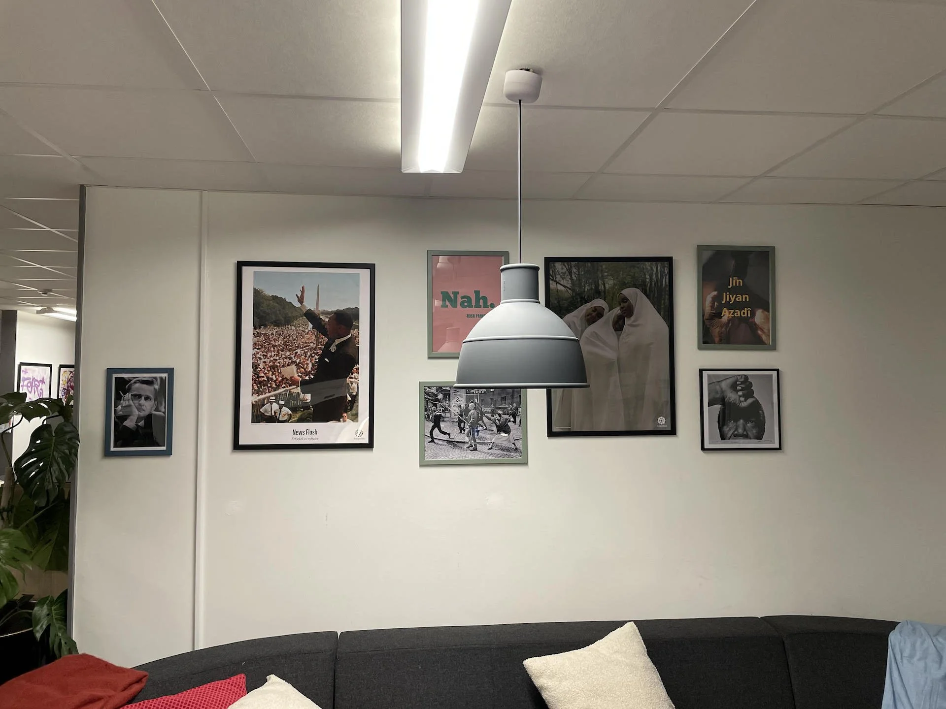 Tavelvägg med inramade bilder om demokrati och mänskliga rättigheter bl.a. Martin Luther King vid Washington-marschen, poster med texten "Nah.", Jin Jian Azadi och svartvita fotografier. En del av en ny miljö skapad för samtal med ungdomar.