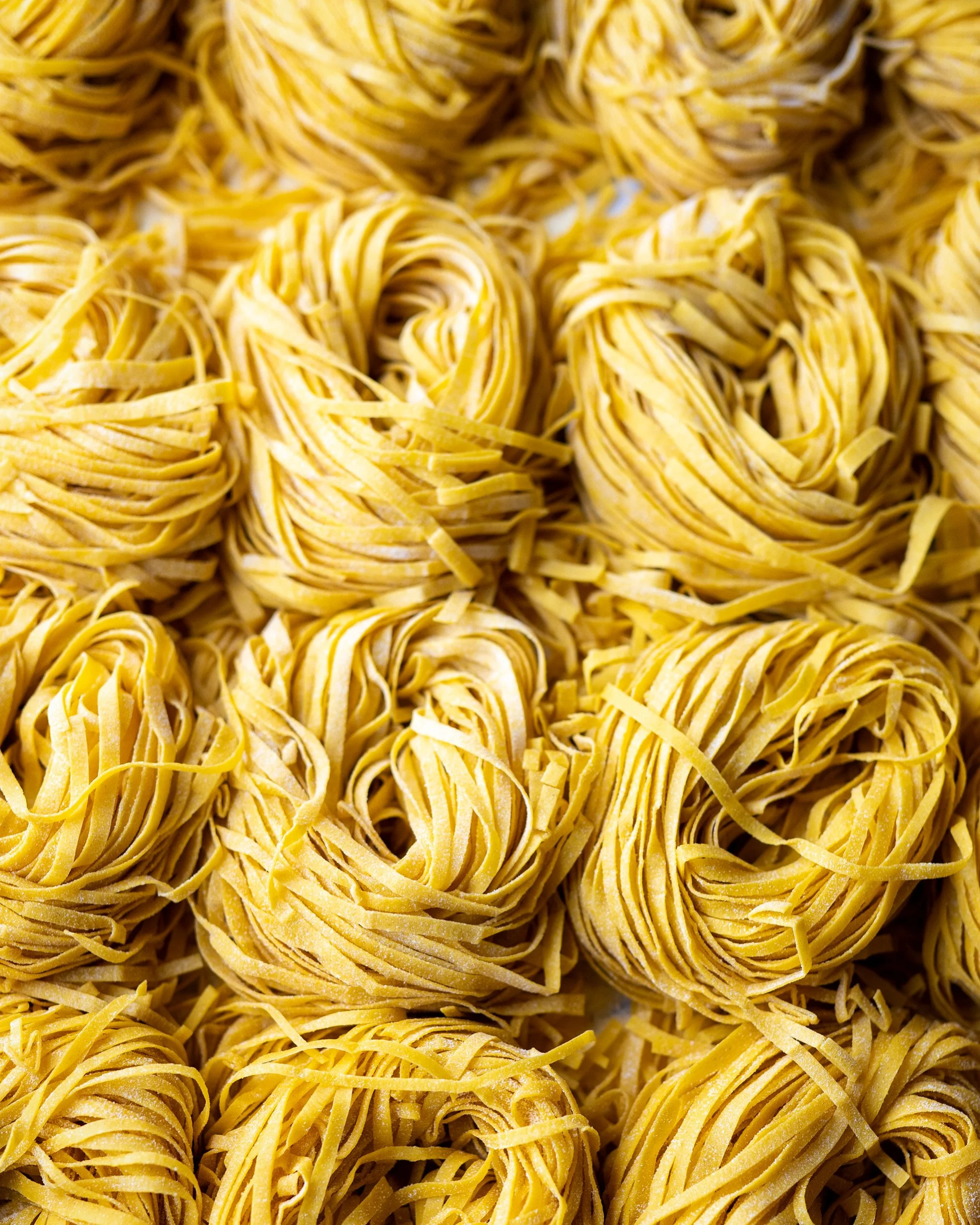 Close-up of dried yellow pasta nests.