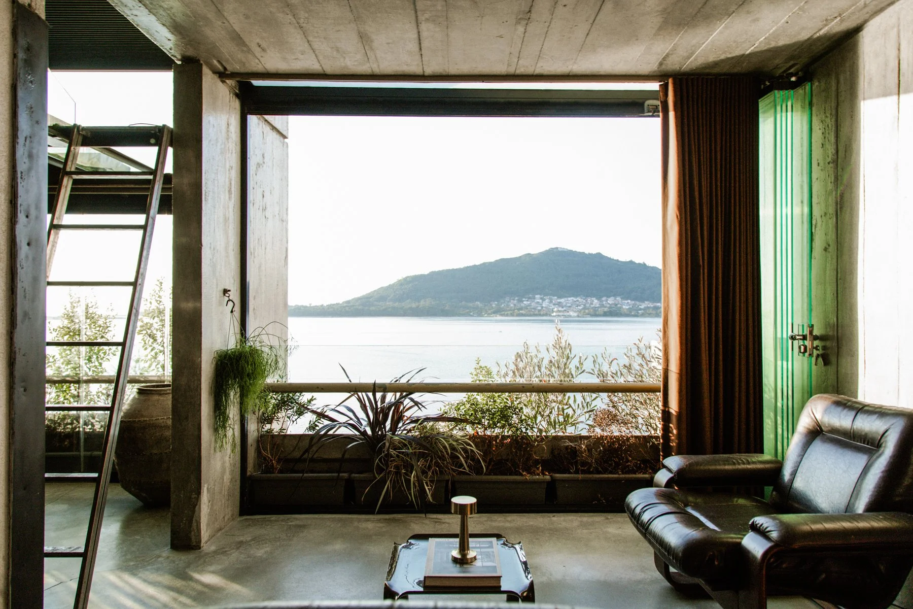Concrete loft living area with floor-to-ceiling window and river view, Curated Property holiday let in Caminha, Portugal