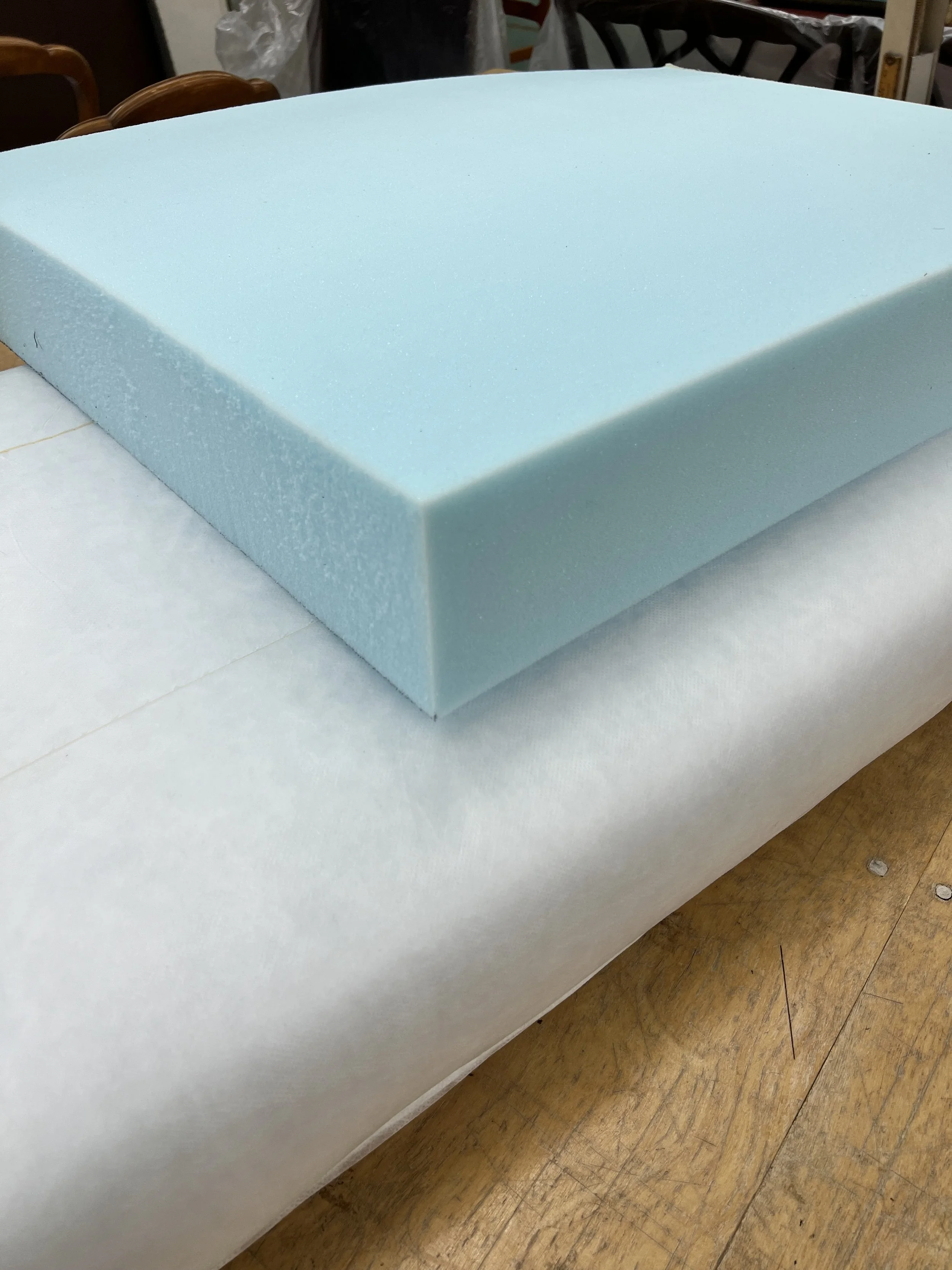 A blue foam block resting on white paper on a wooden table.