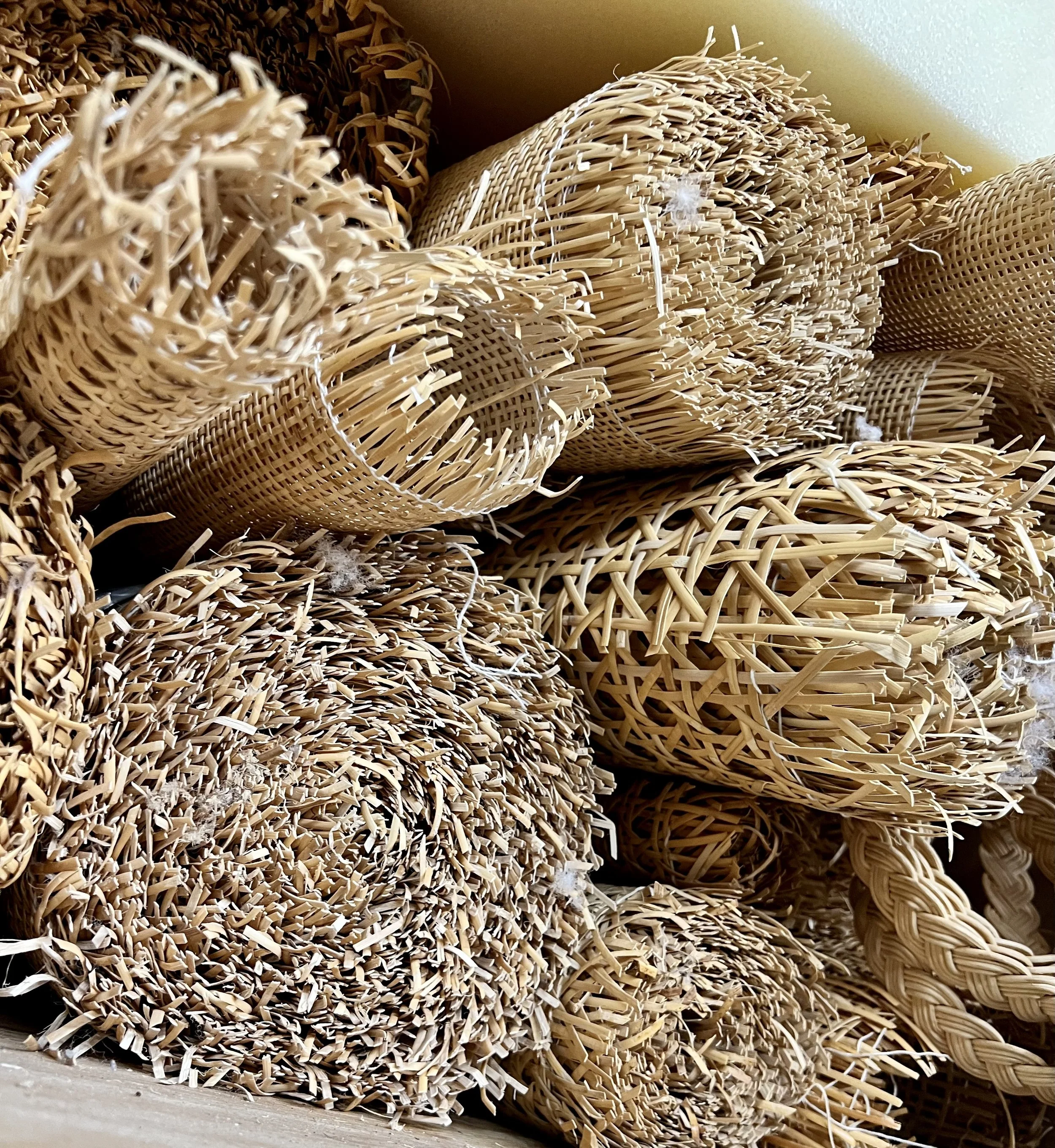 A close-up view of rolled and woven bamboo mats or baskets in various shapes and sizes.