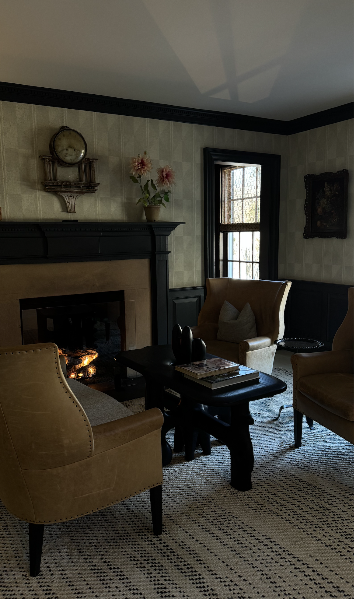 Intimate sitting room at the Mayflower Inn with a fireplace, leather chairs, and a coffee table.
