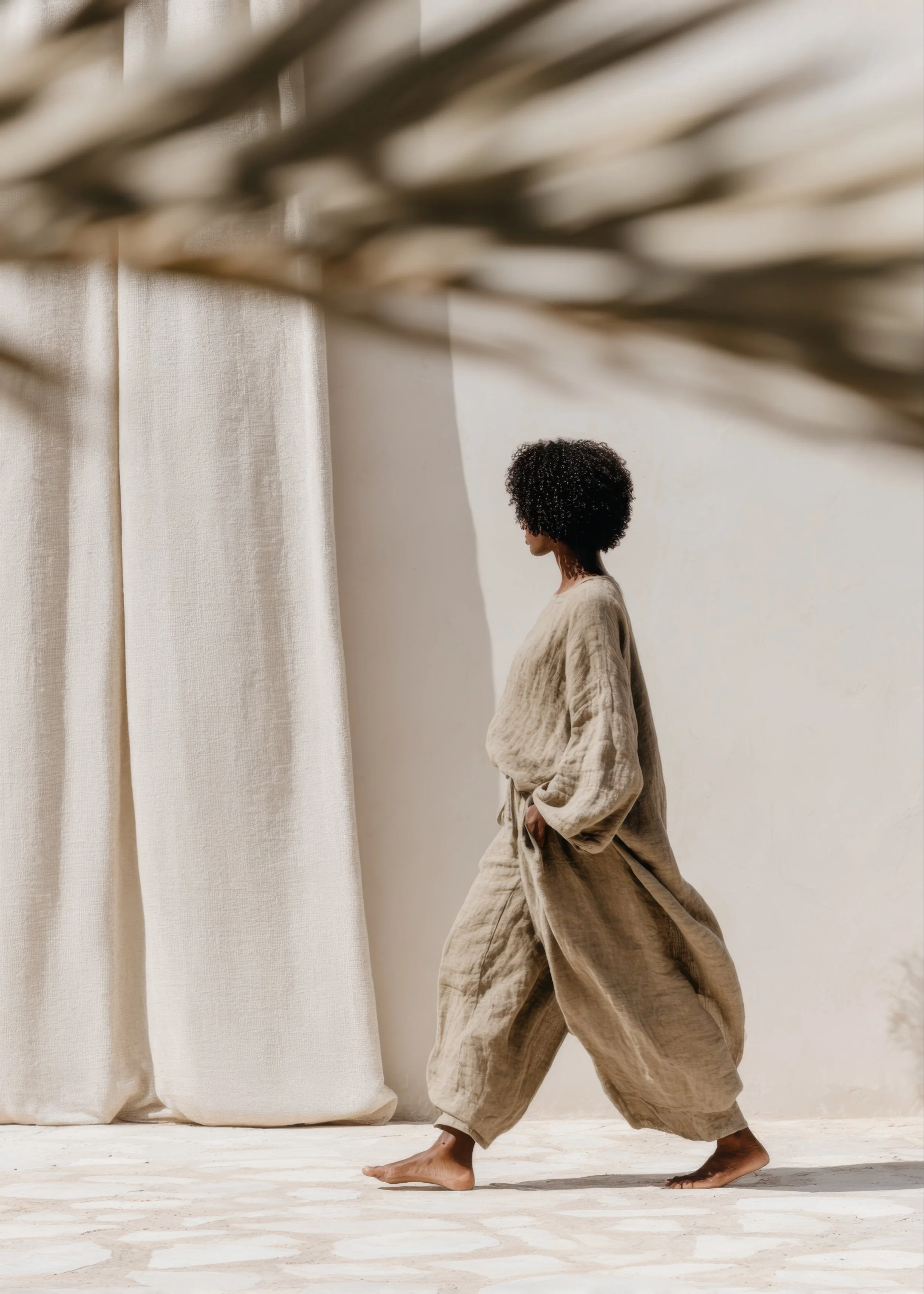 Woman walking calmly through a soft, light-filled space with neutral tones