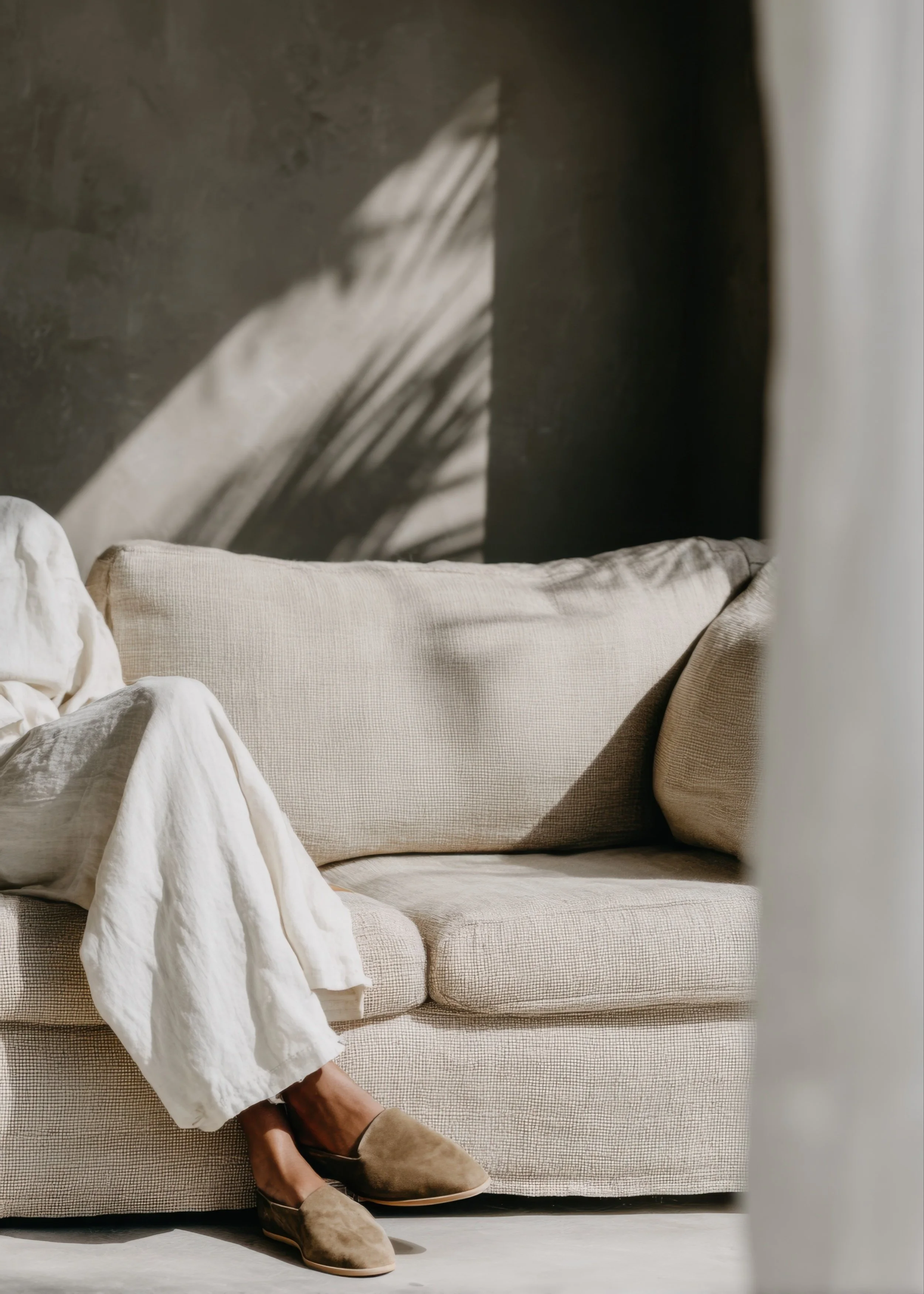 Person sitting on a couch in a calm, neutral-toned space