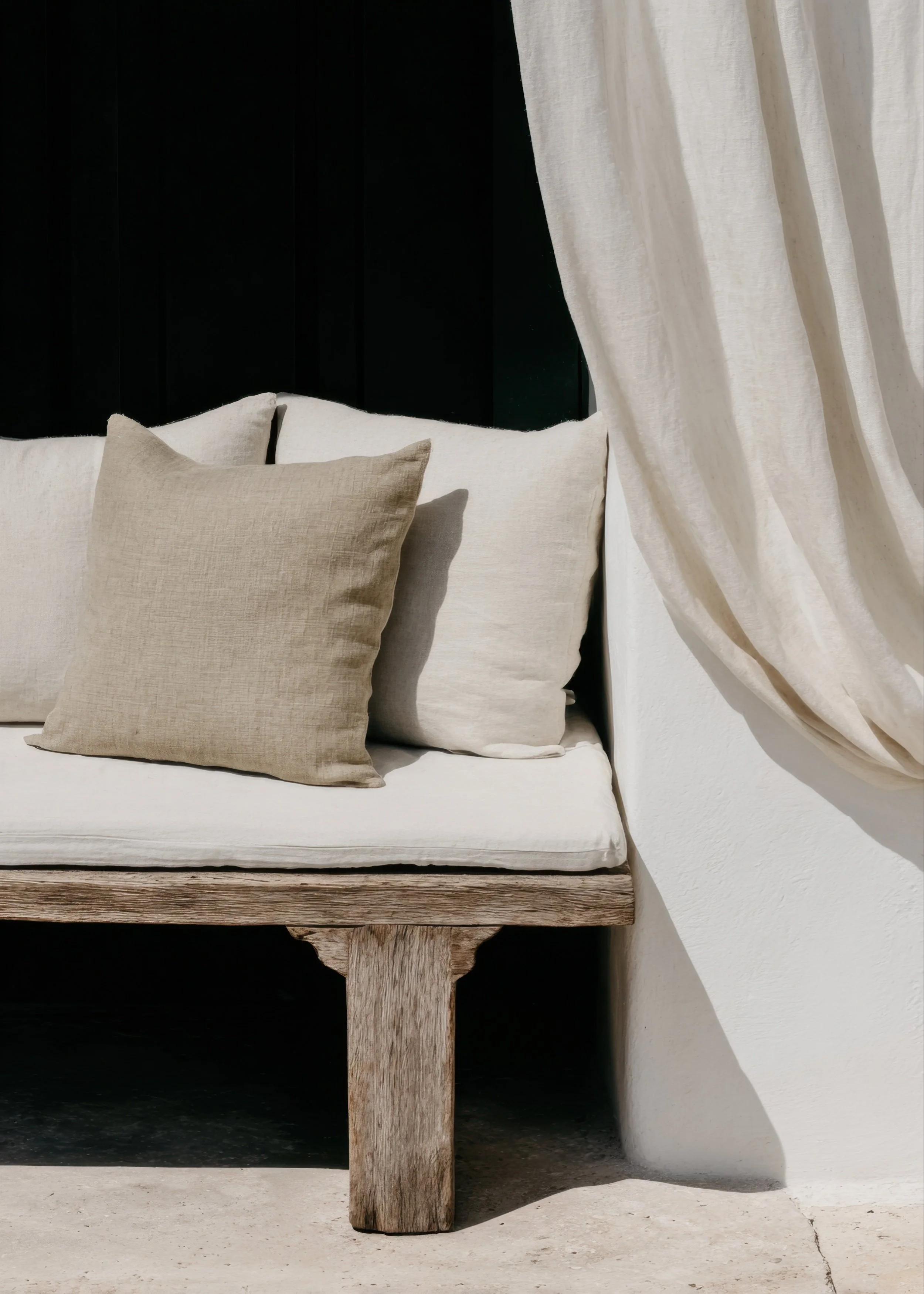 Neutral cushioned seating in a calm, sunlit space