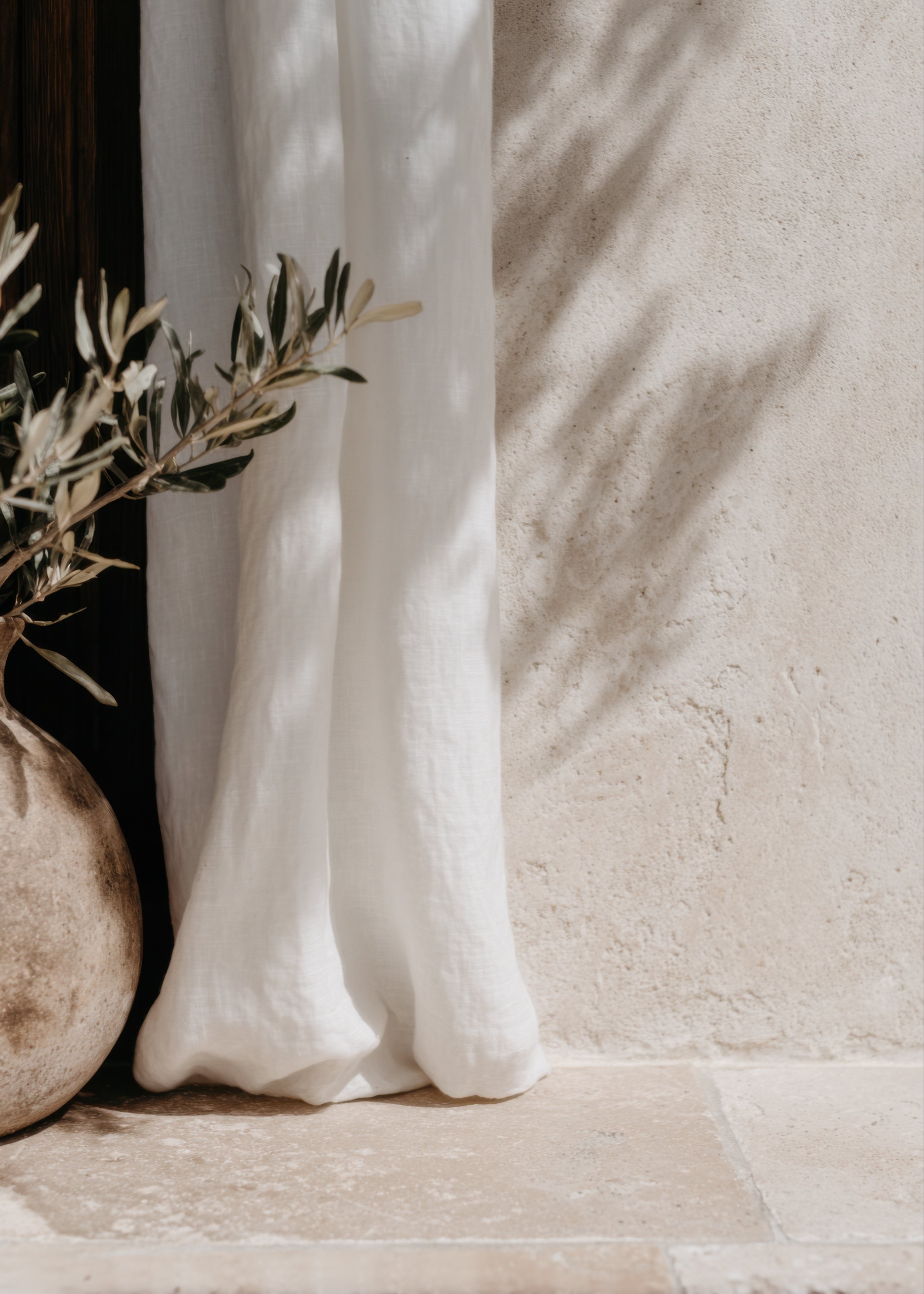 Soft, neutral-toned interior with natural linen curtains, warm sunlight, and organic textures creating a calm and restorative therapy-inspired space