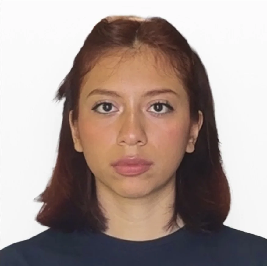 Portrait of a person with short brown hair, wearing a dark shirt, on a plain white background.