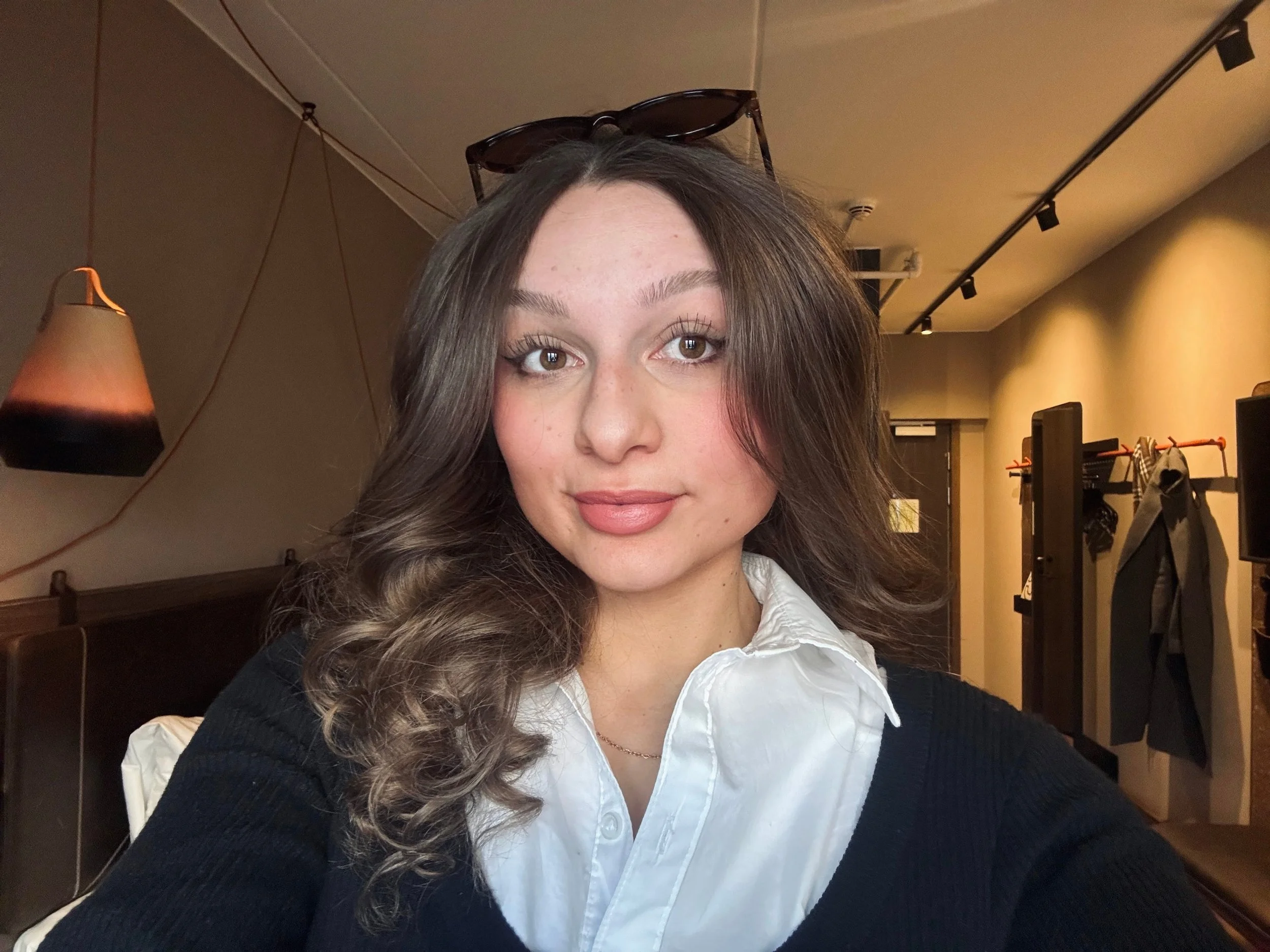 A young woman wearing sunglasses on her head and smiling