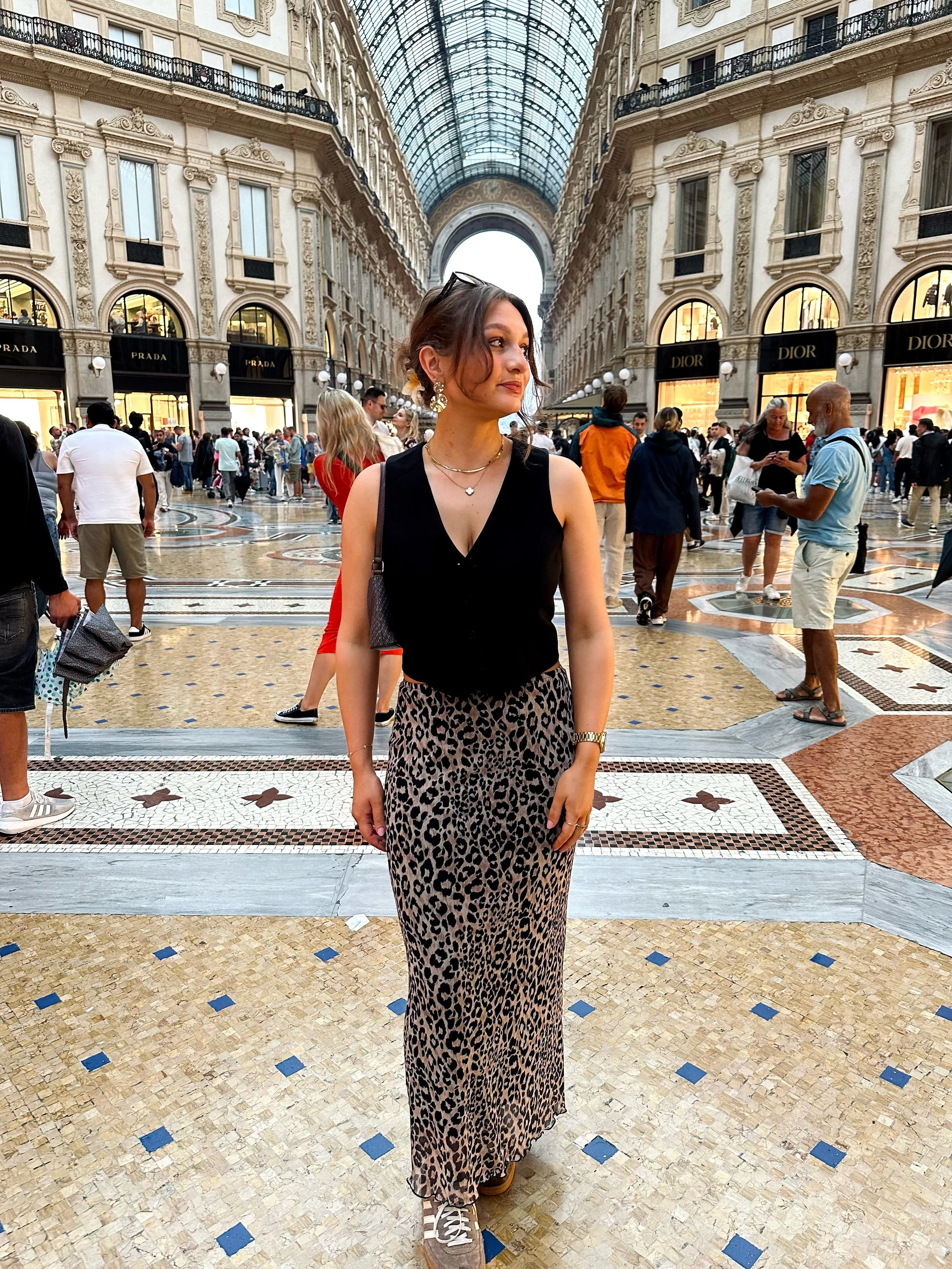 A woman standing in the Galleria Vittorio Emanuele II in Malin, wearing a leopard print skirt