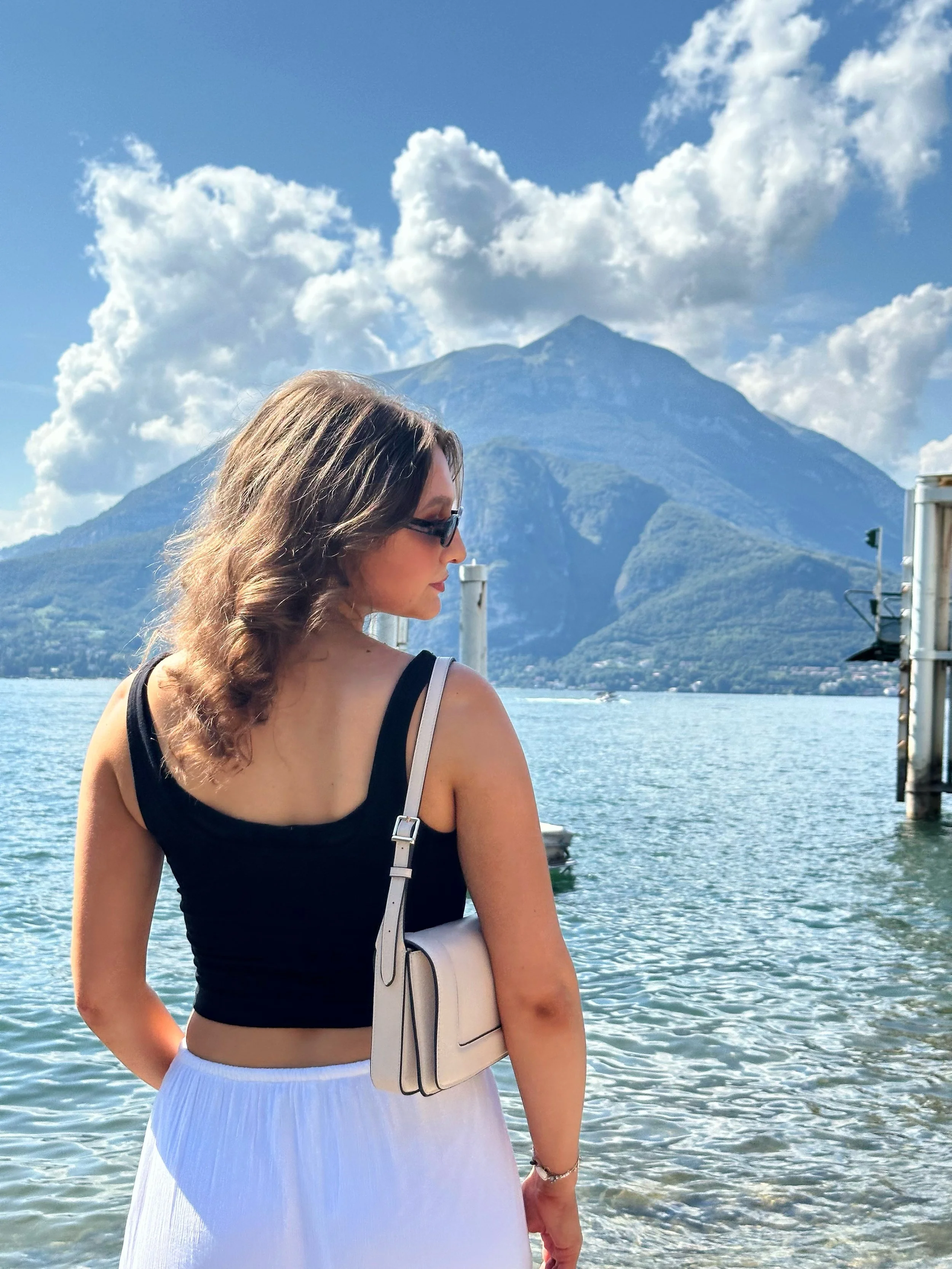 A woman standing in front of Lake Como with the mountains in the background