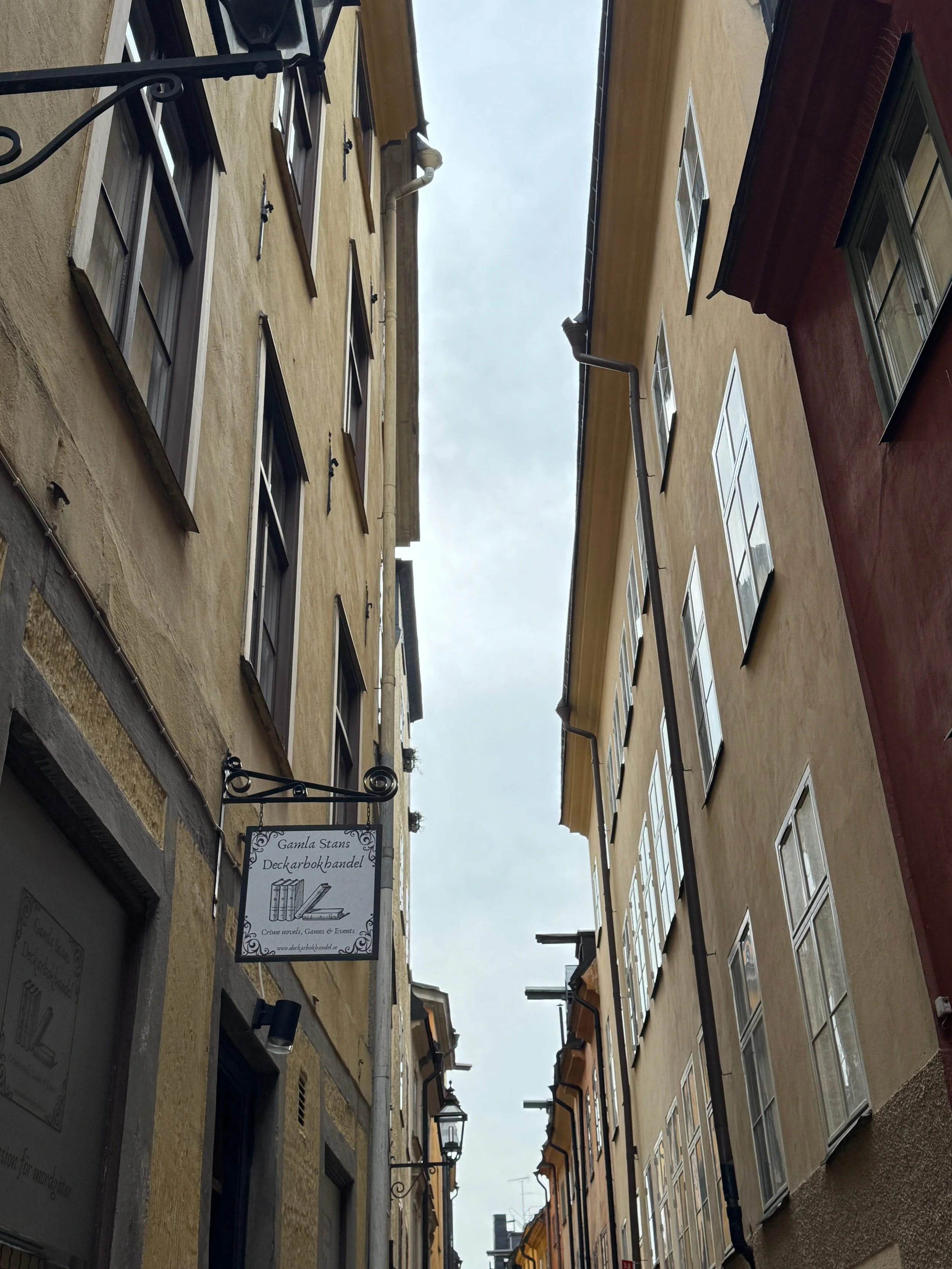 A bookshop sign hanging in the colourful streets of Gamla Stan in Stockholm