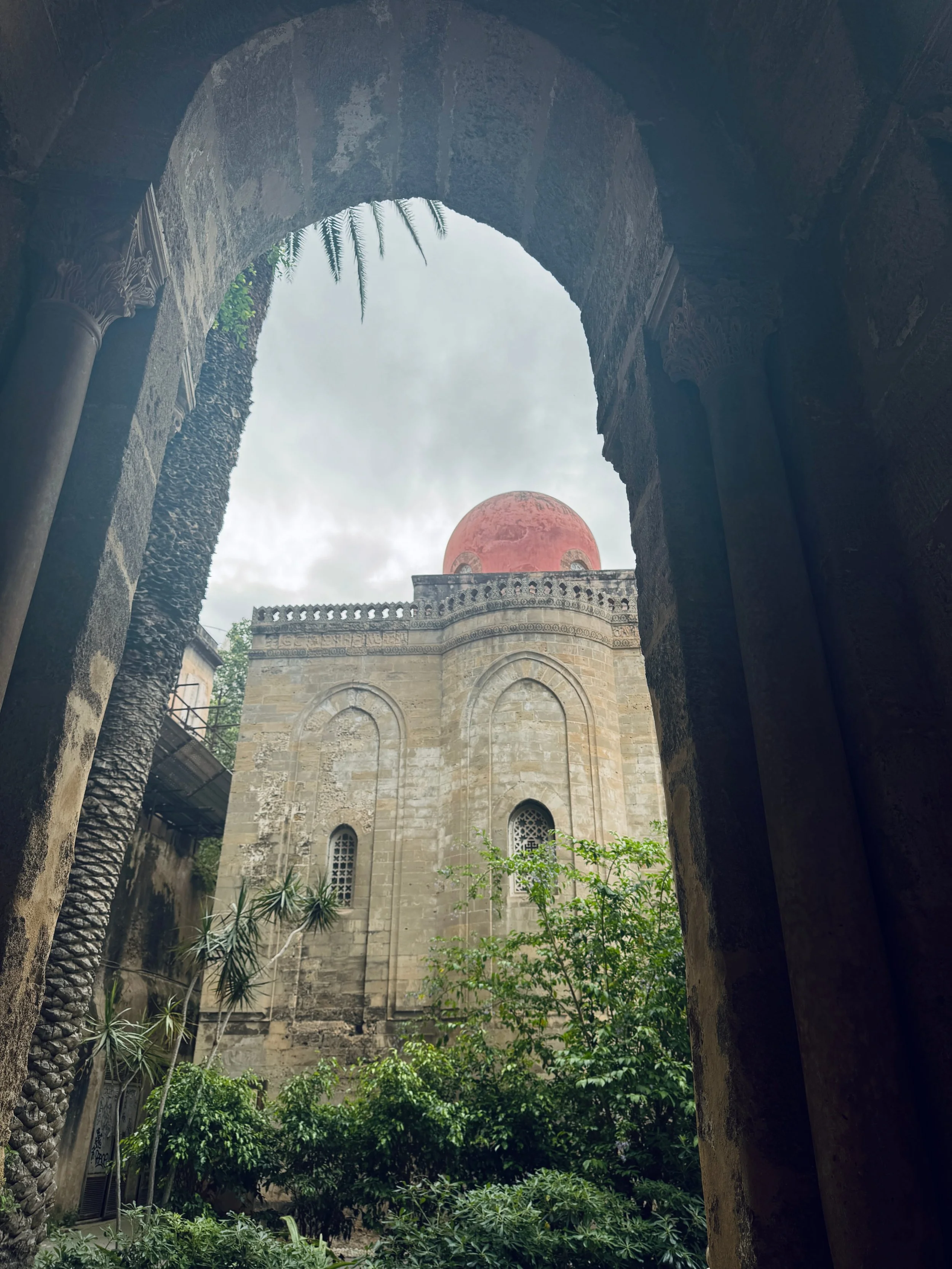 A historic building framed by a stone archway, showcasing its intricate architecture and weathered charm.